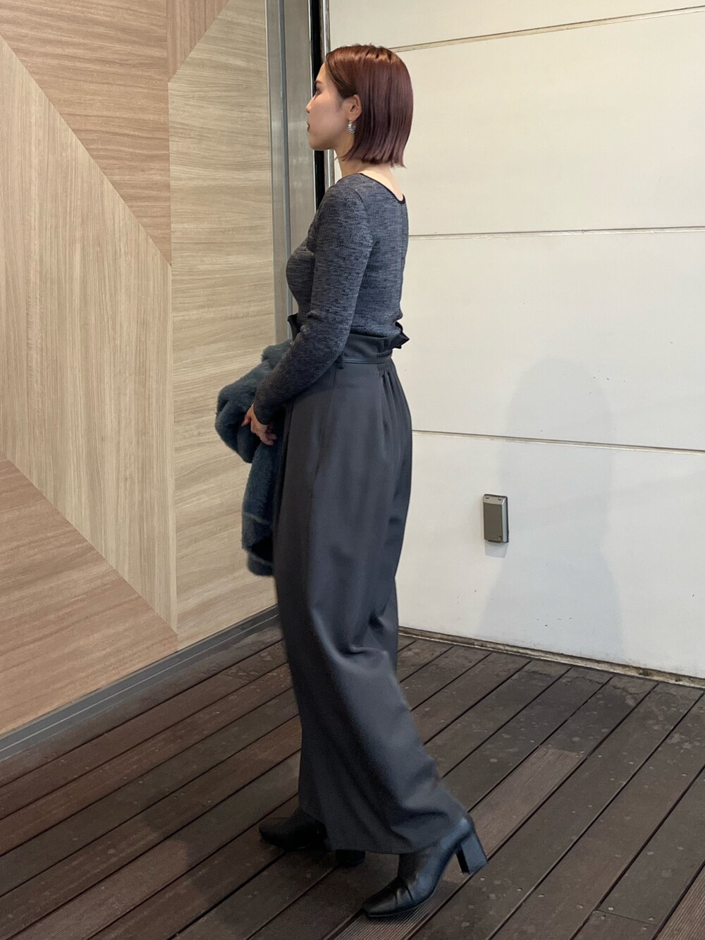 グレー系のその他パンツ、ブラック系のニット/セーターを着用したレディースの秋コーディネートの2枚目の写真