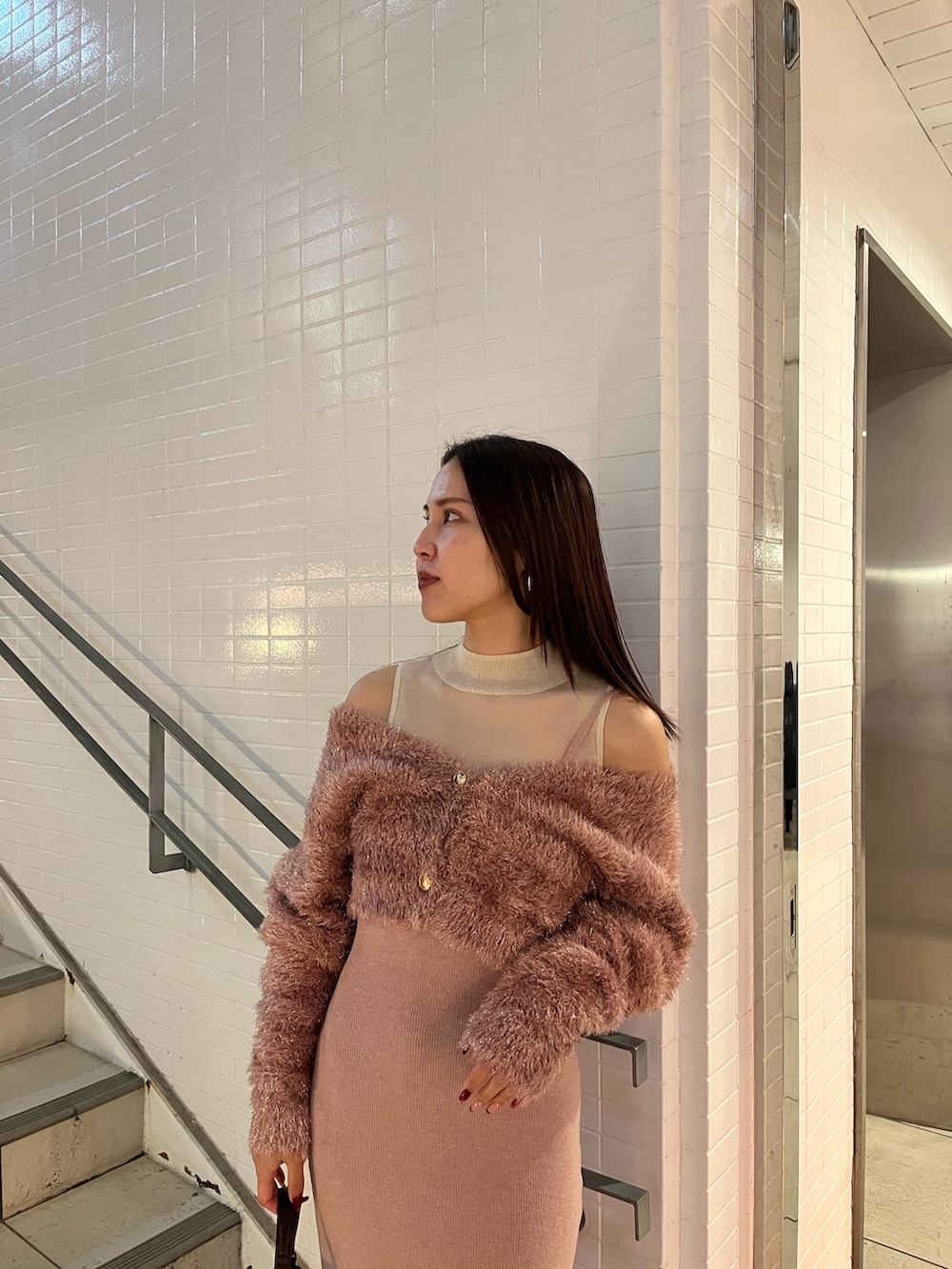 ピンク系のワンピース、ブラウン系のハンドバッグを着用したレディースの冬コーディネートの4枚目の写真