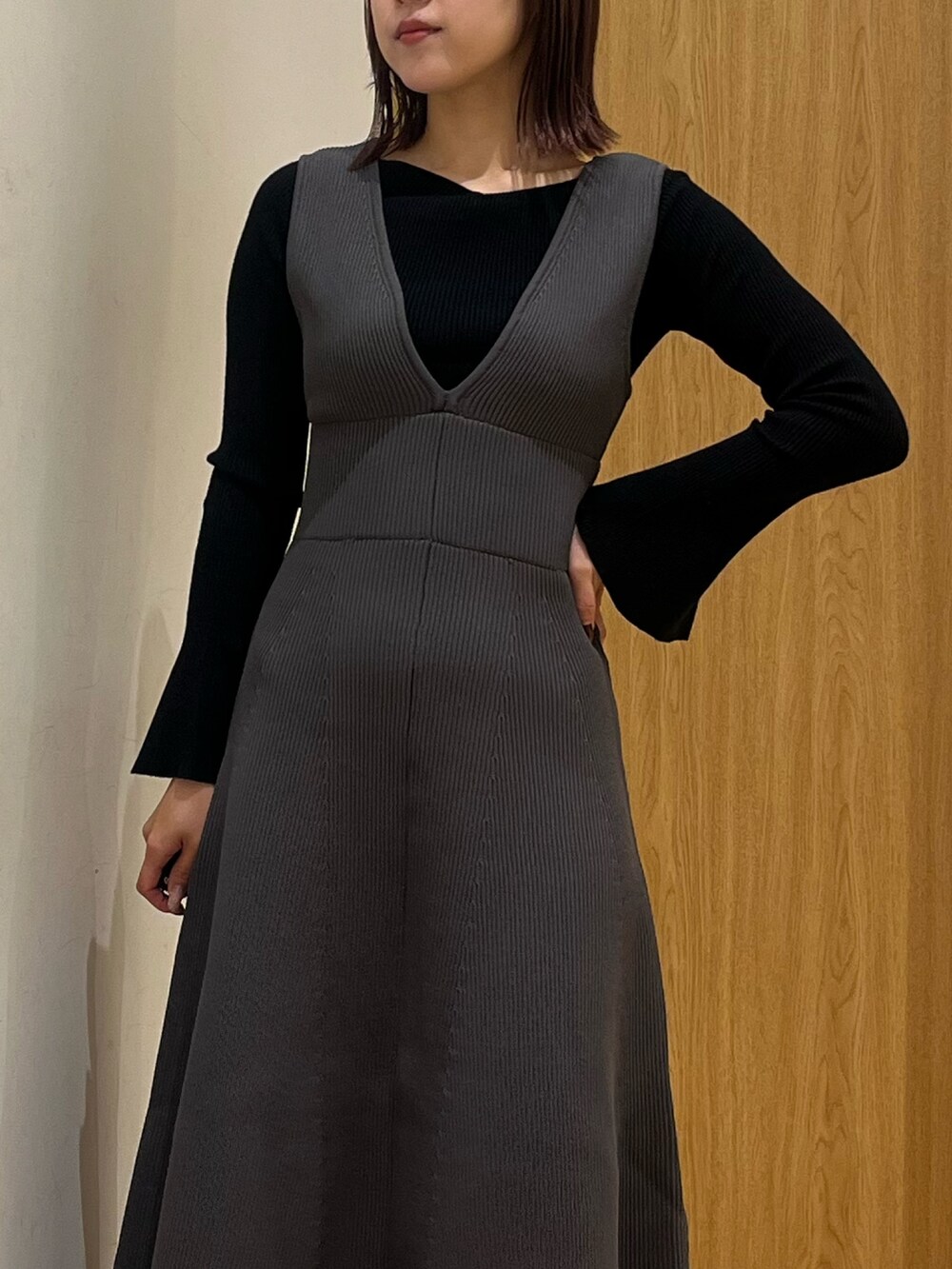 ブラック系のブーツ、ブラック系のニット/セーター、グレー系のジャンパースカートを着用したレディースの冬コーディネートの4枚目の写真