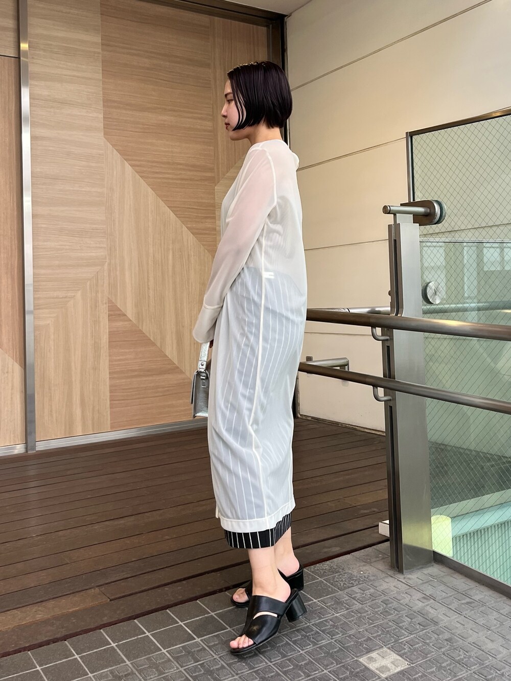 ホワイト系のTシャツ/カットソー、ブラック系のサンダル、ブラック系のスカートを着用したレディースの春コーディネートの2枚目の写真