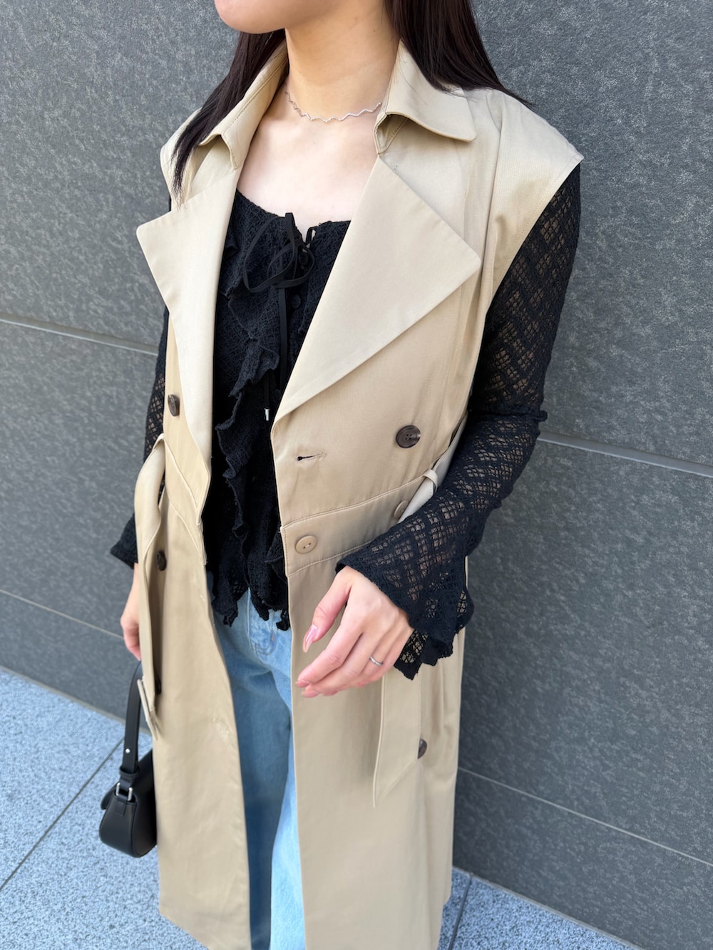 ブラック系のシャツ/ブラウス、ブルー系のデニムパンツ、ベージュ系のトレンチコートを着用したレディースの冬コーディネートの9枚目の写真