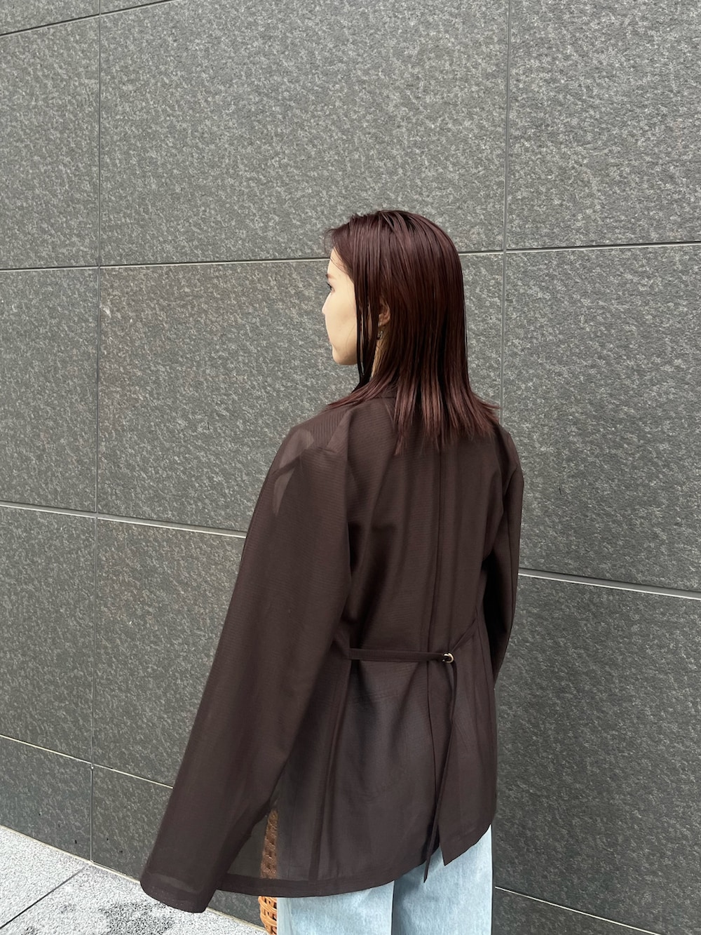 ブラック系のサンダル、ブルー系のデニムパンツ、ブラウン系のテーラードジャケットを着用したレディースの夏コーディネートの5枚目の写真