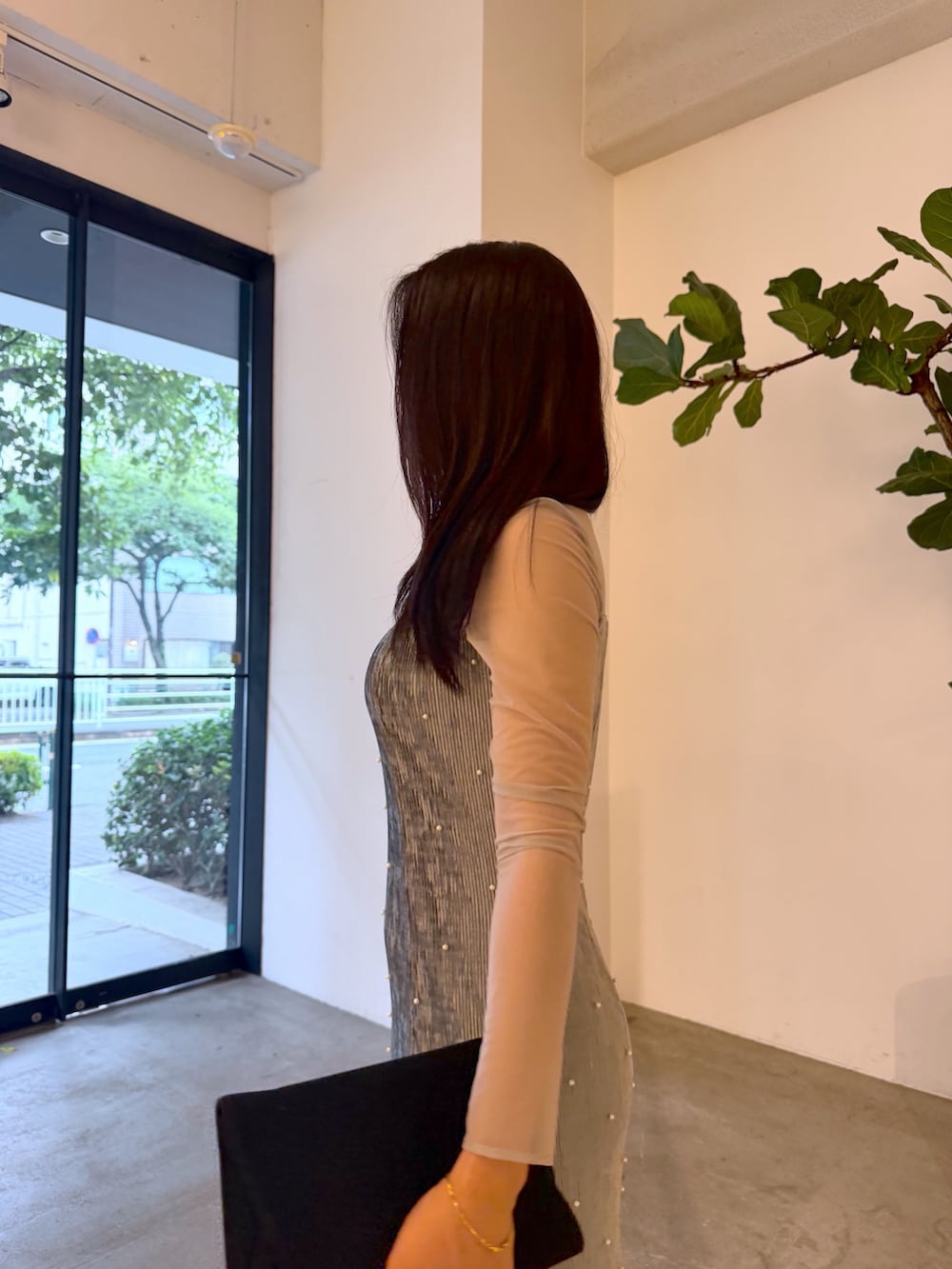ブラック系のクラッチバッグ、ブルー系のドレス、シルバー系のパンプスを着用したレディースの夏コーディネートの5枚目の写真