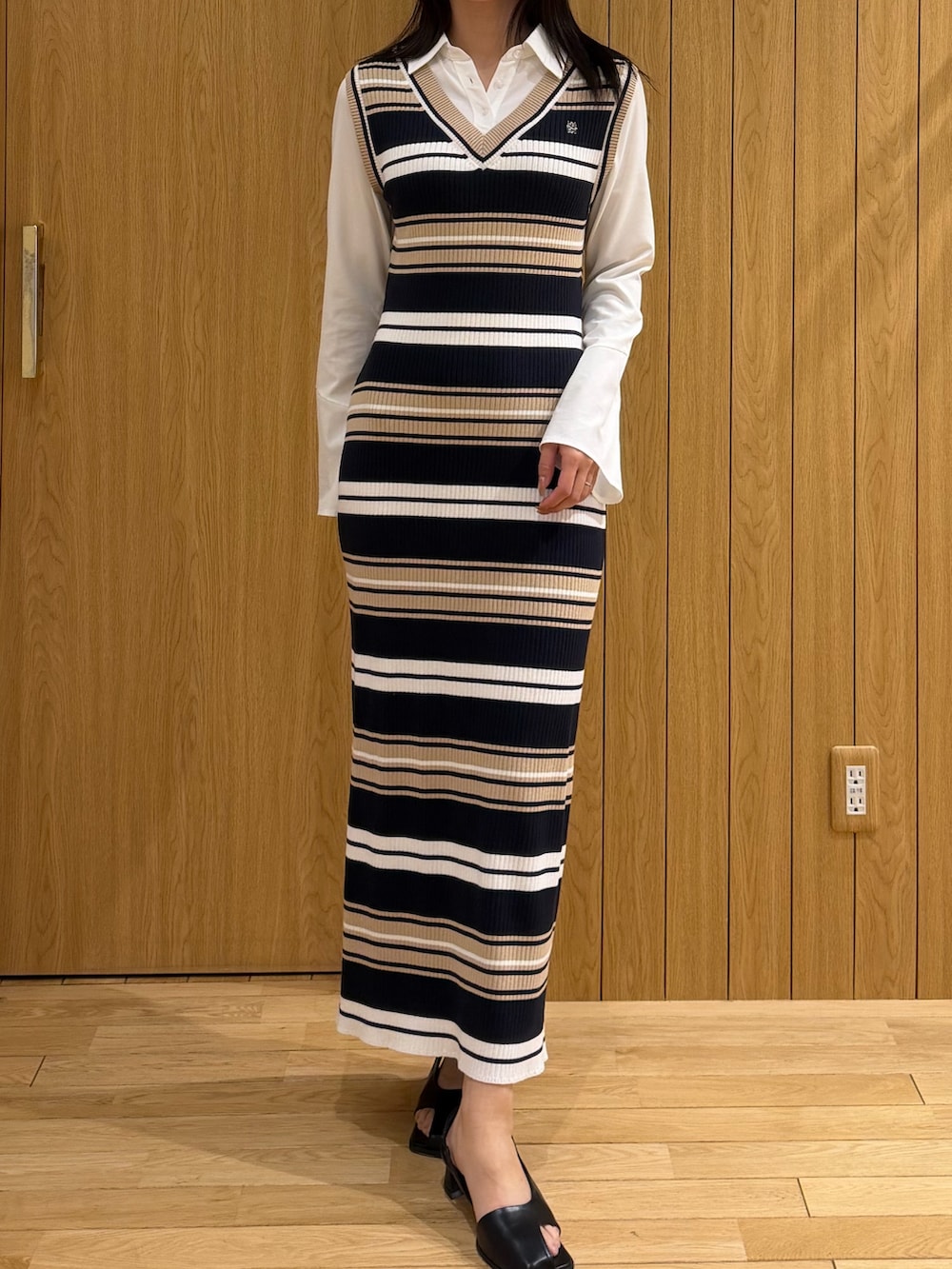 ベージュ系のワンピース、ブラック系のサンダルを着用したレディースの冬コーディネートの4枚目の写真