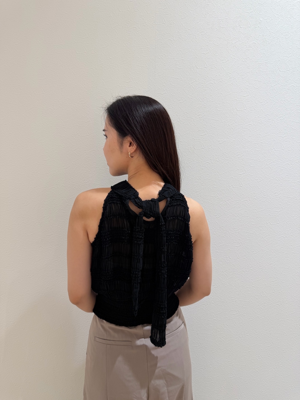 ブラウン系のハンドバッグ、ベージュ系のその他パンツ、ブラック系のシャツ/ブラウスを着用したレディースの夏コーディネートの5枚目の写真