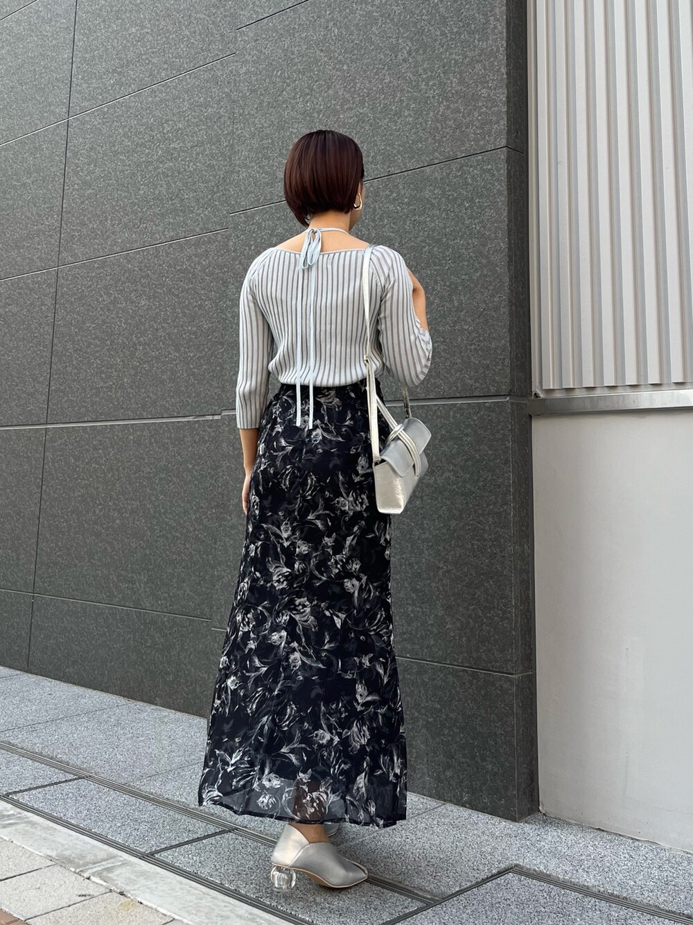 ブラック系のスカート、シルバー系のパンプス、ブルー系のニット/セーターを着用したレディースの春コーディネートの3枚目の写真