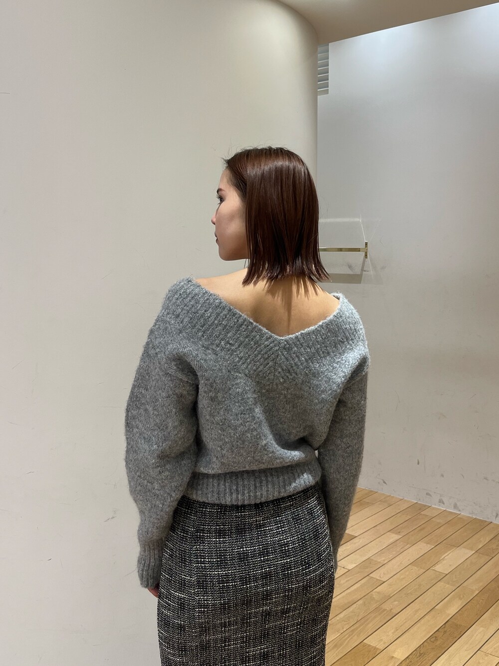 グレー系のニット/セーター、ブラック系のスカートを着用したレディースの冬コーディネートの4枚目の写真