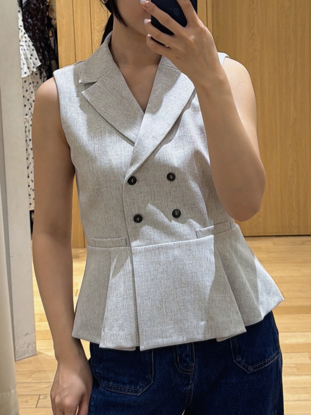ブルー系のデニムパンツ、ホワイト系のベストを着用したレディースの春コーディネートの6枚目の写真