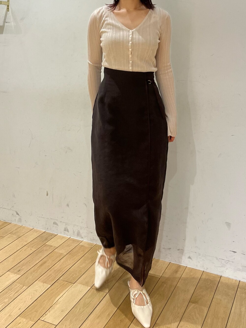 ブラウン系のスカート、ホワイト系のTシャツ/カットソー、ホワイト系のサンダルを着用したレディースの春コーディネートの4枚目の写真