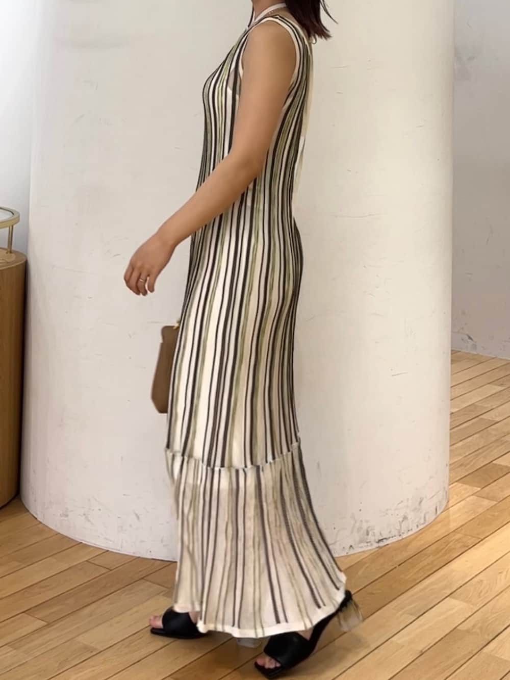 ブラウン系のハンドバッグ、ホワイト系のワンピース、ベージュ系のテーラードジャケットを着用したレディースの春コーディネートの4枚目の写真