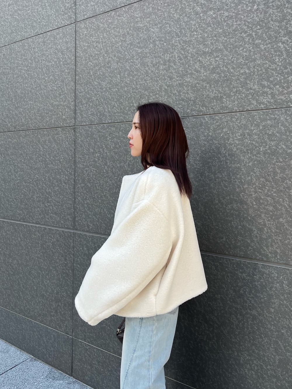 ブルー系のアンサンブル、ブルー系のデニムパンツ、ホワイト系のブルゾンを着用したレディースの冬コーディネートの9枚目の写真