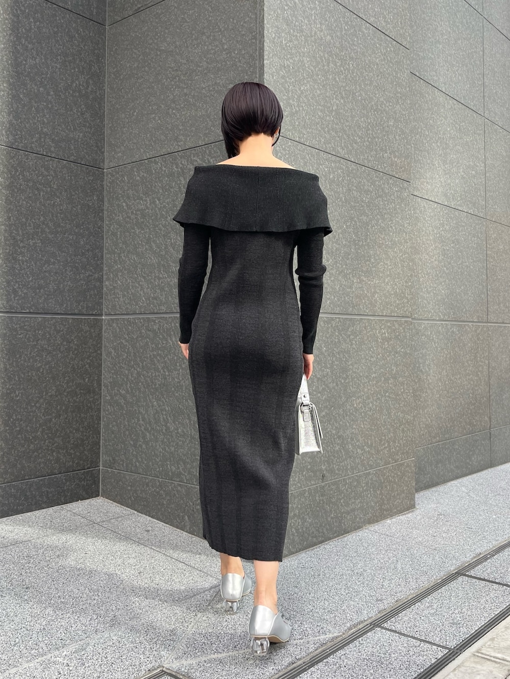 シルバー系のショルダーバッグ、シルバー系のパンプス、ブラック系のワンピースを着用したレディースの春コーディネートの3枚目の写真