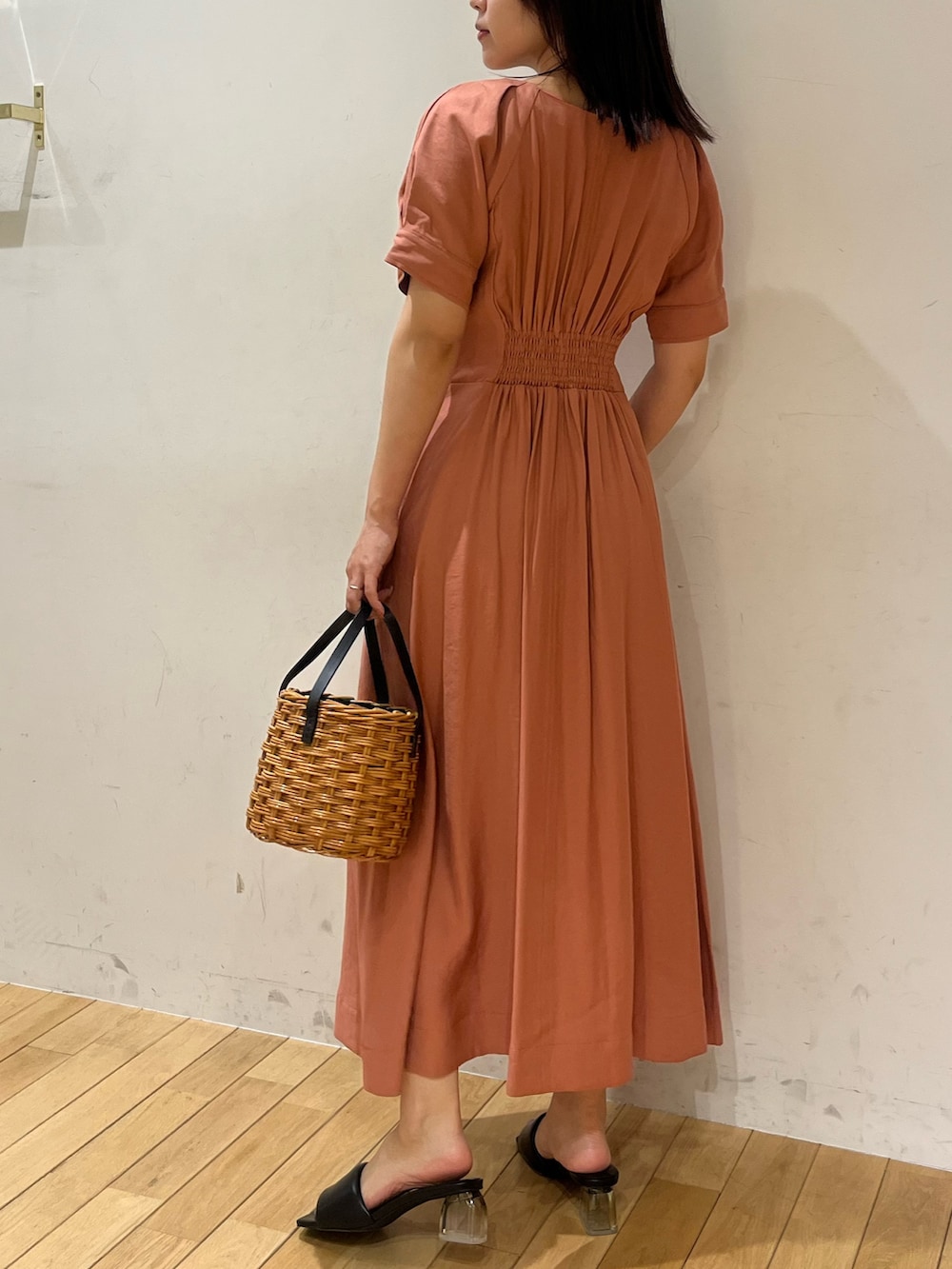 ブラウン系のハンドバッグ、ブラック系のサンダル、ピンク系のワンピースを着用したレディースの夏コーディネートの3枚目の写真