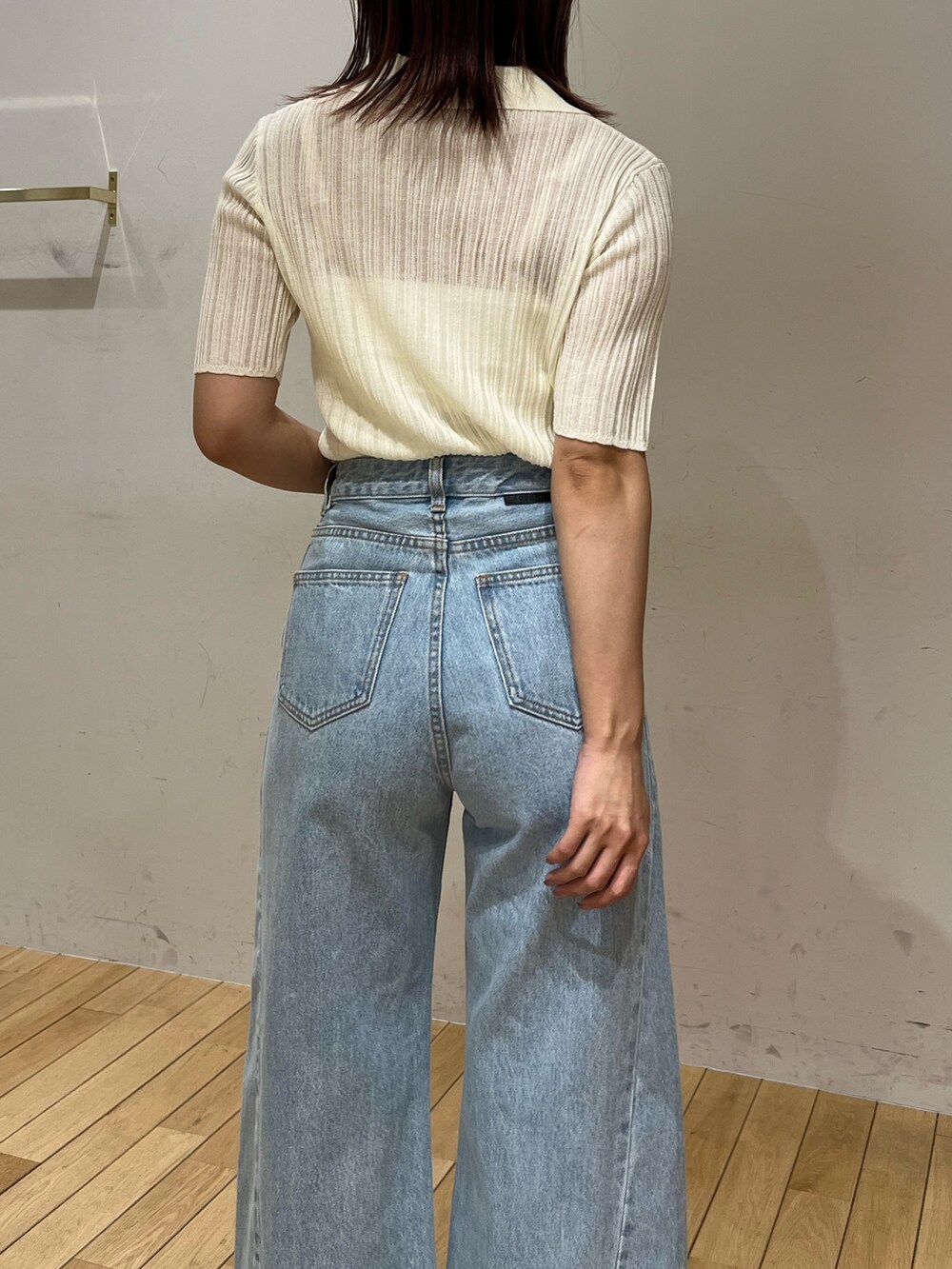 ブルー系のデニムパンツ、ブラック系のサンダル、ホワイト系のTシャツ/カットソーを着用したレディースの春コーディネートの6枚目の写真