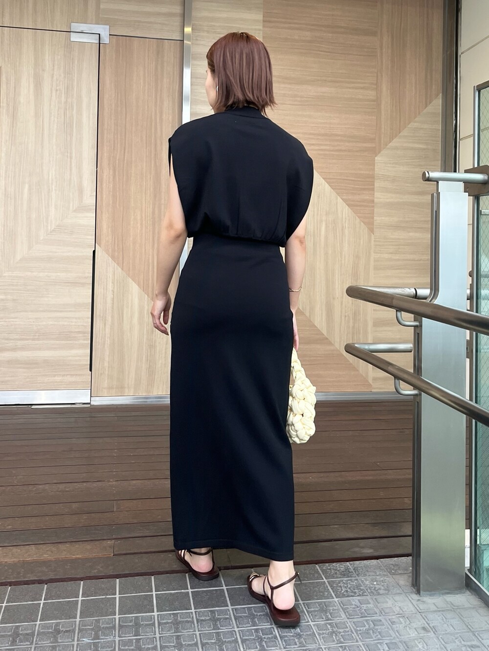 ブラック系のサンダル、ホワイト系のハンドバッグ、ブラック系のニット/セーターを着用したレディースの夏コーディネートの3枚目の写真