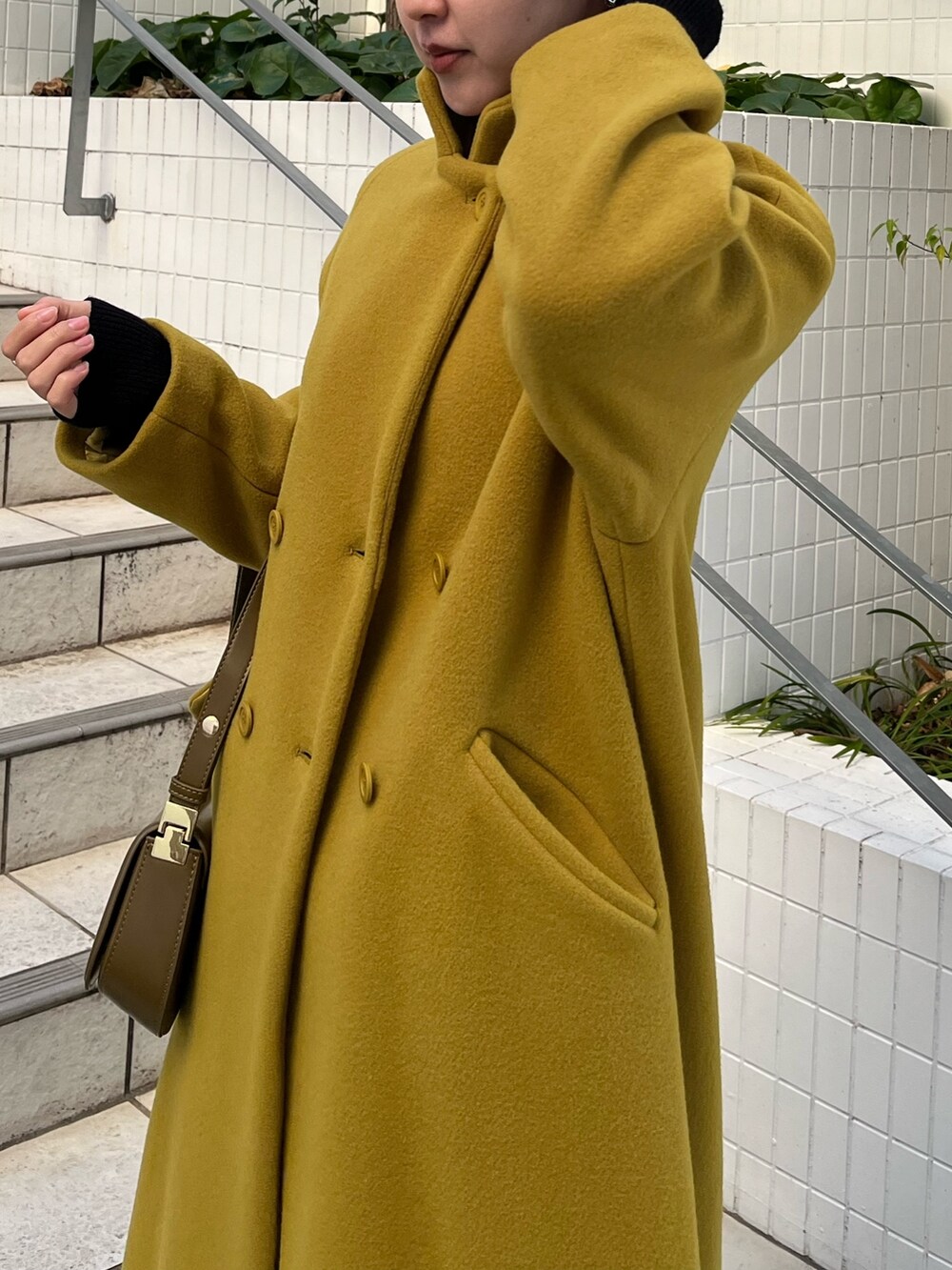 グリーン系のチェスターコート、ブラック系のその他パンツ、ブラック系のニット/セーターを着用したレディースの冬コーディネートの7枚目の写真