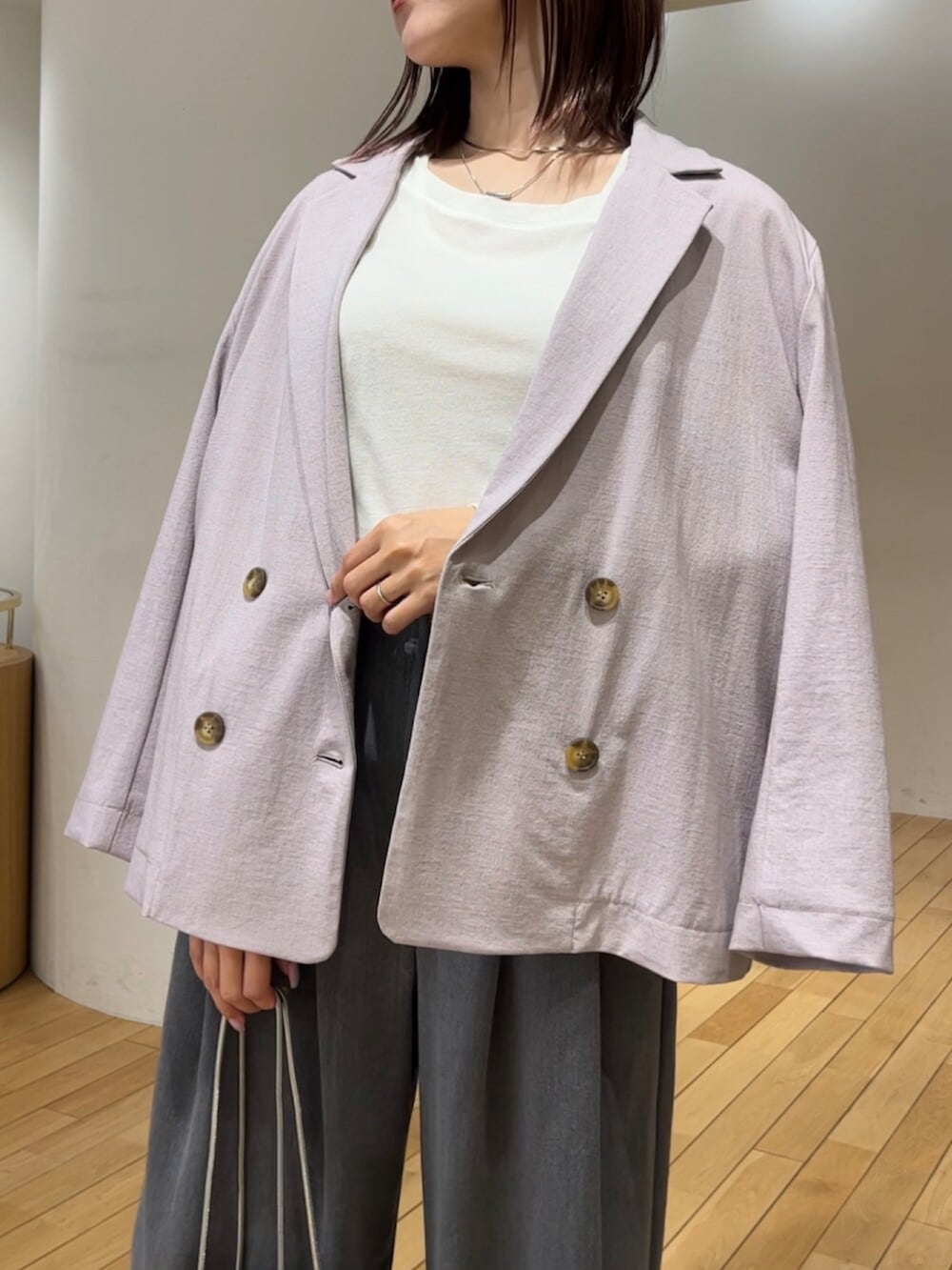 ホワイト系のサンダル、パープル系のテーラードジャケット、グレー系のその他パンツを着用したレディースの春コーディネートの6枚目の写真