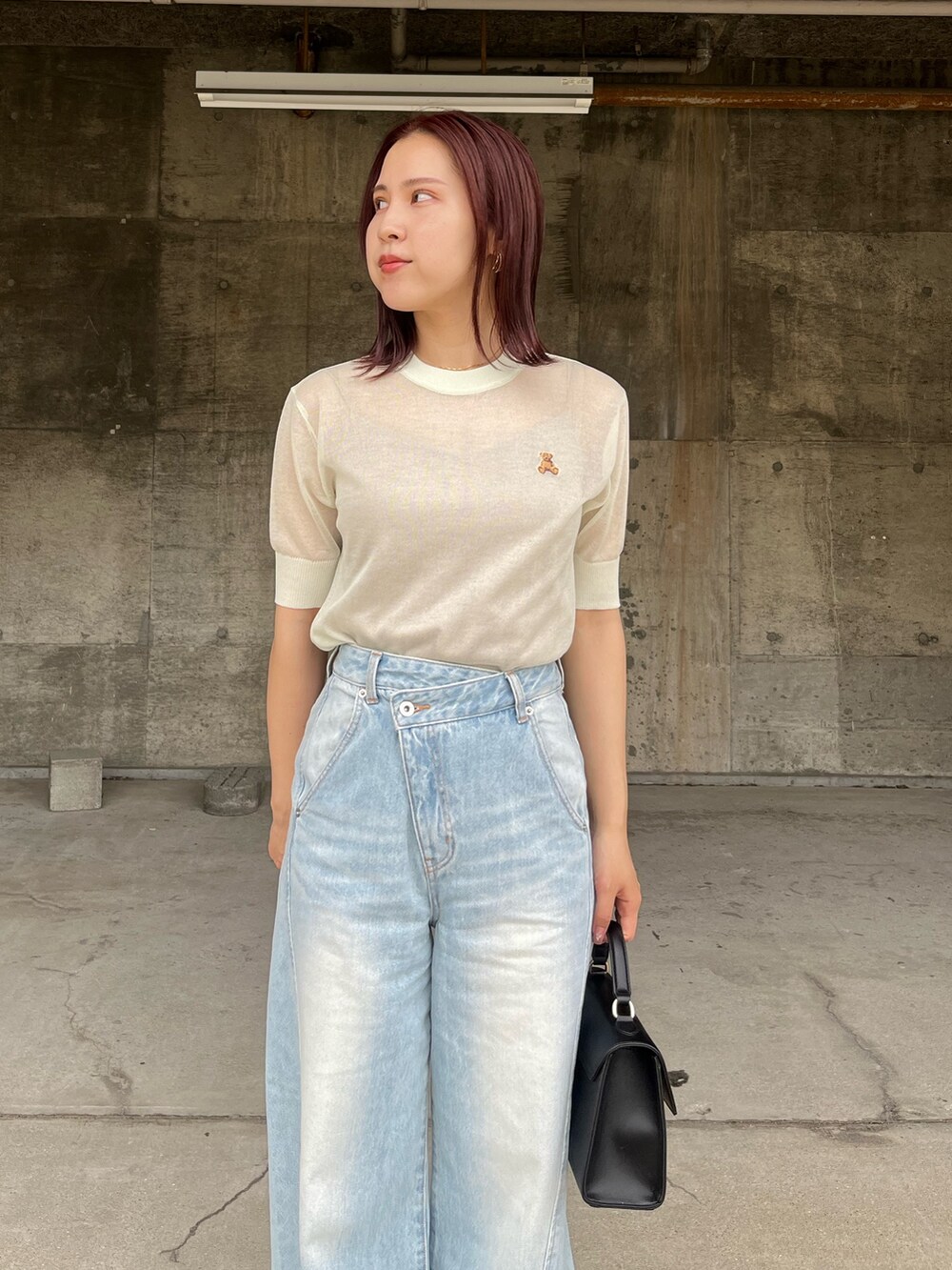 グリーン系のTシャツ/カットソー、ブルー系のデニムパンツ、ブラック系のハンドバッグを着用したレディースの春コーディネートの4枚目の写真
