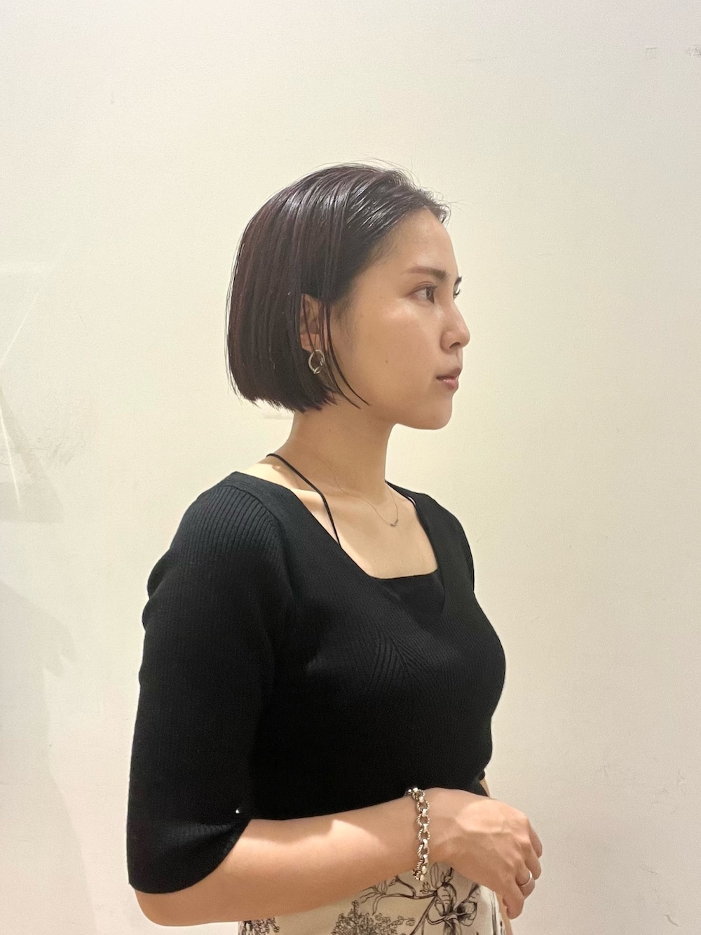 イエロー系のスカート、ブラック系のハンドバッグ、ブラック系のニット/セーターを着用したレディースの秋コーディネートの5枚目の写真