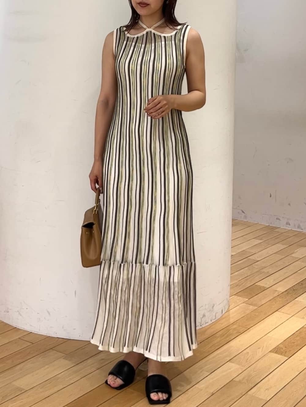 ブラウン系のハンドバッグ、ホワイト系のワンピース、ベージュ系のテーラードジャケットを着用したレディースの春コーディネートの3枚目の写真