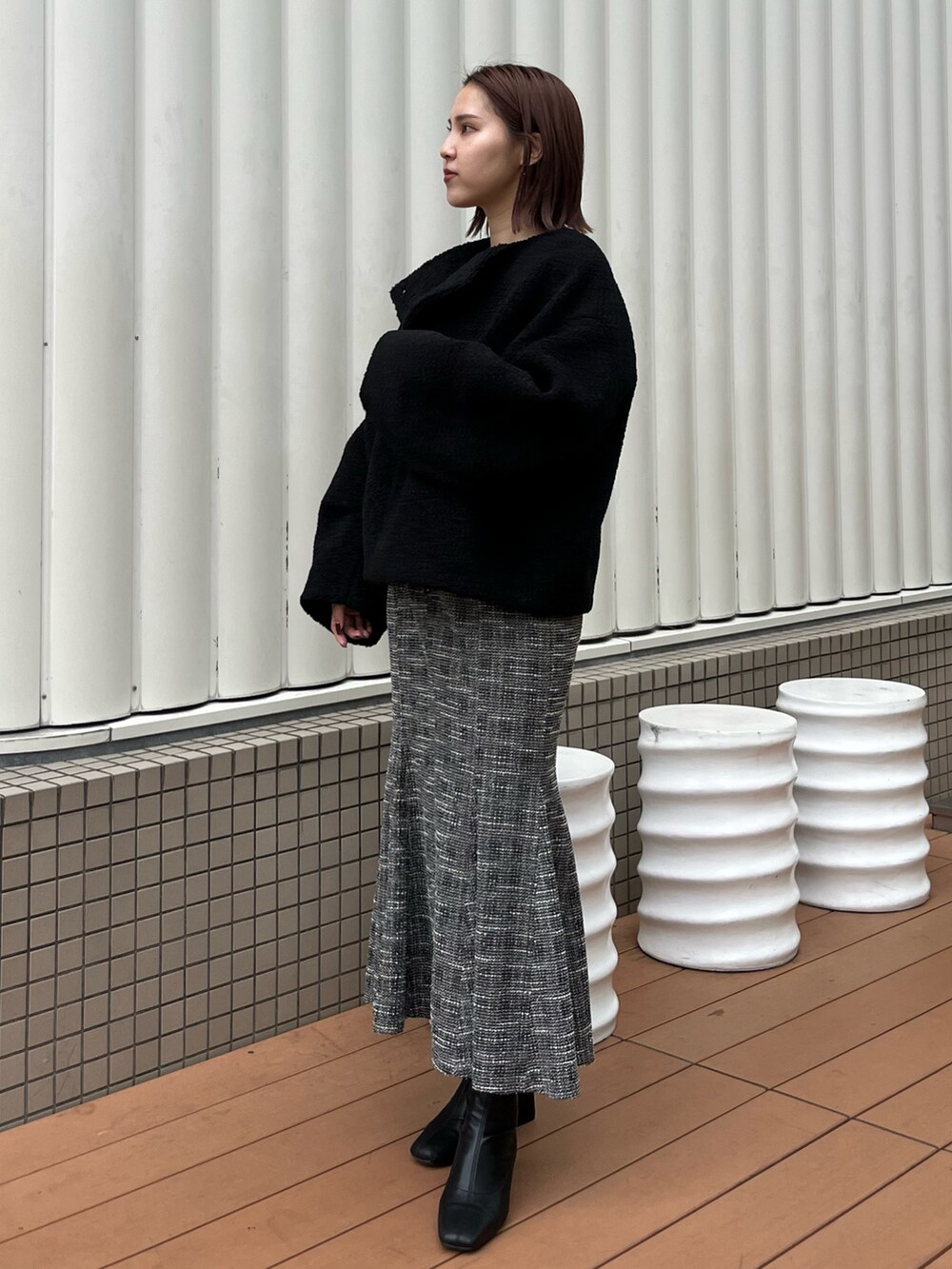 ブラック系のブルゾン、ブラック系のニット/セーター、ブラック系のスカートを着用したレディースの秋コーディネートの2枚目の写真