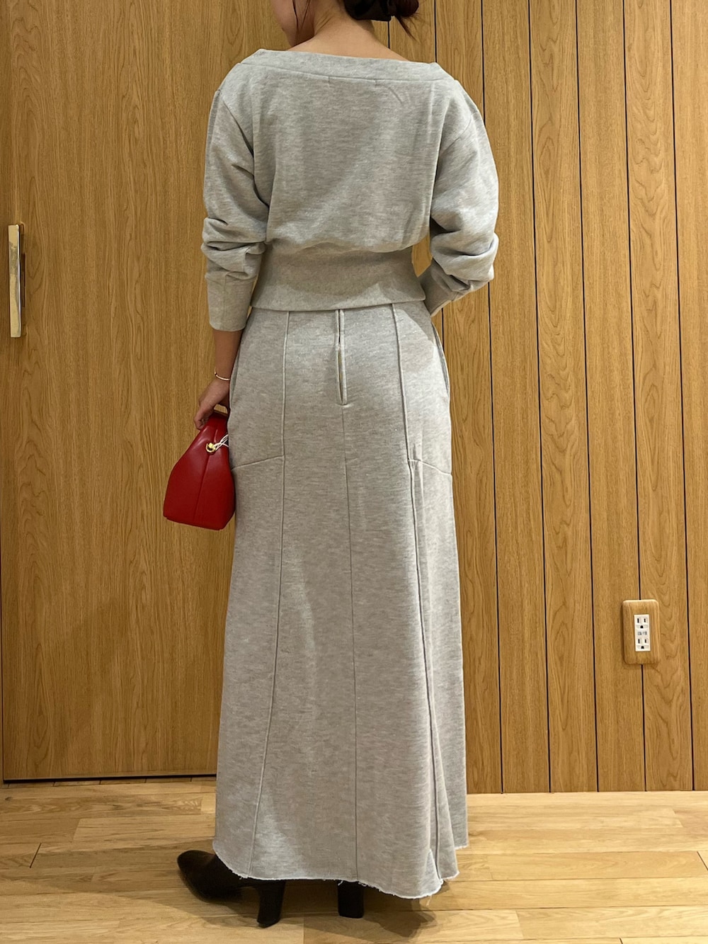 グレー系のスウェット、グレー系のスカート、レッド系のハンドバッグを着用したレディースの秋コーディネートの4枚目の写真