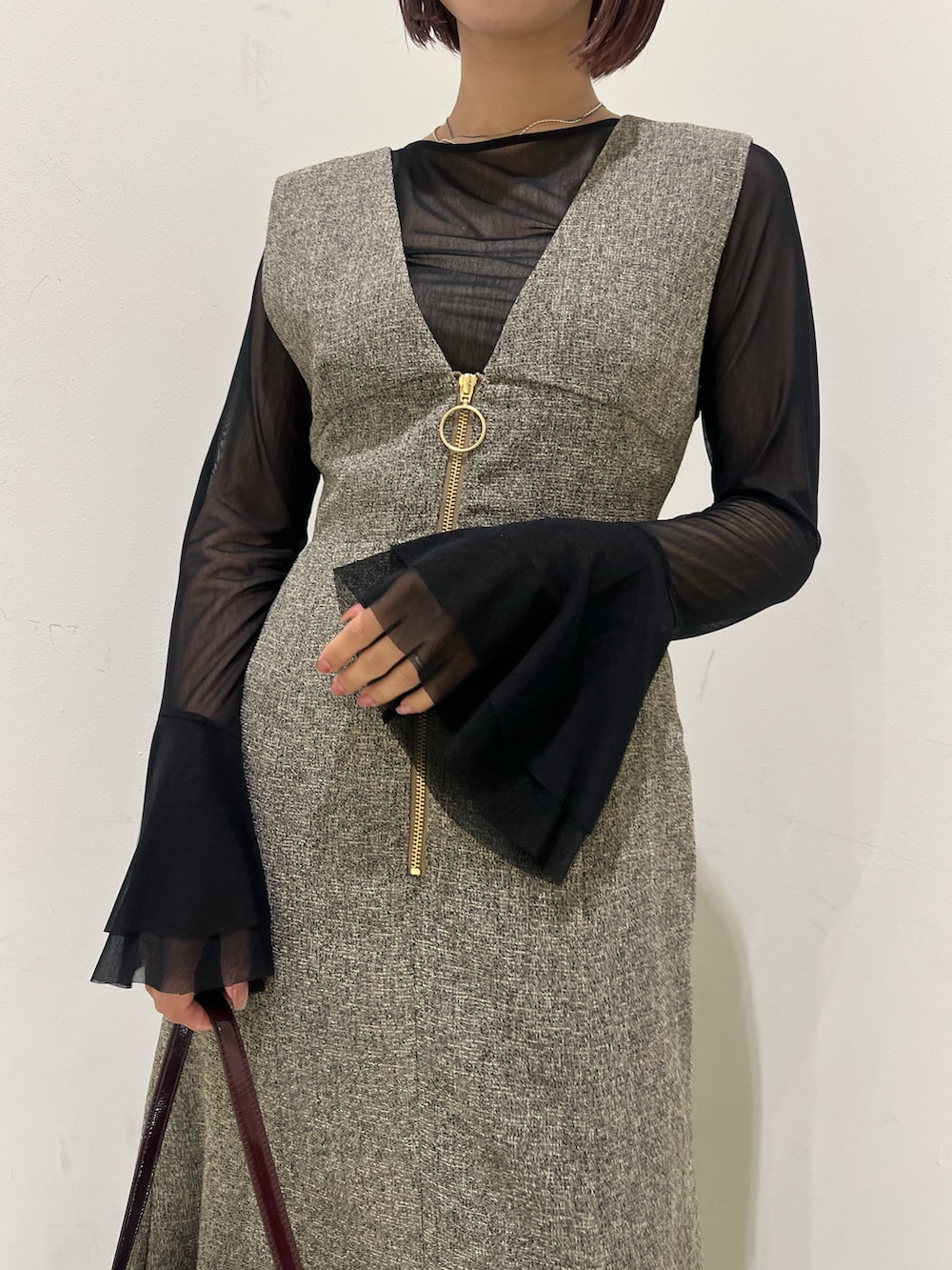 ベージュ系のジャンパースカート、ブラック系のTシャツ/カットソー、ブラック系のブーツを着用したレディースの秋コーディネートの6枚目の写真