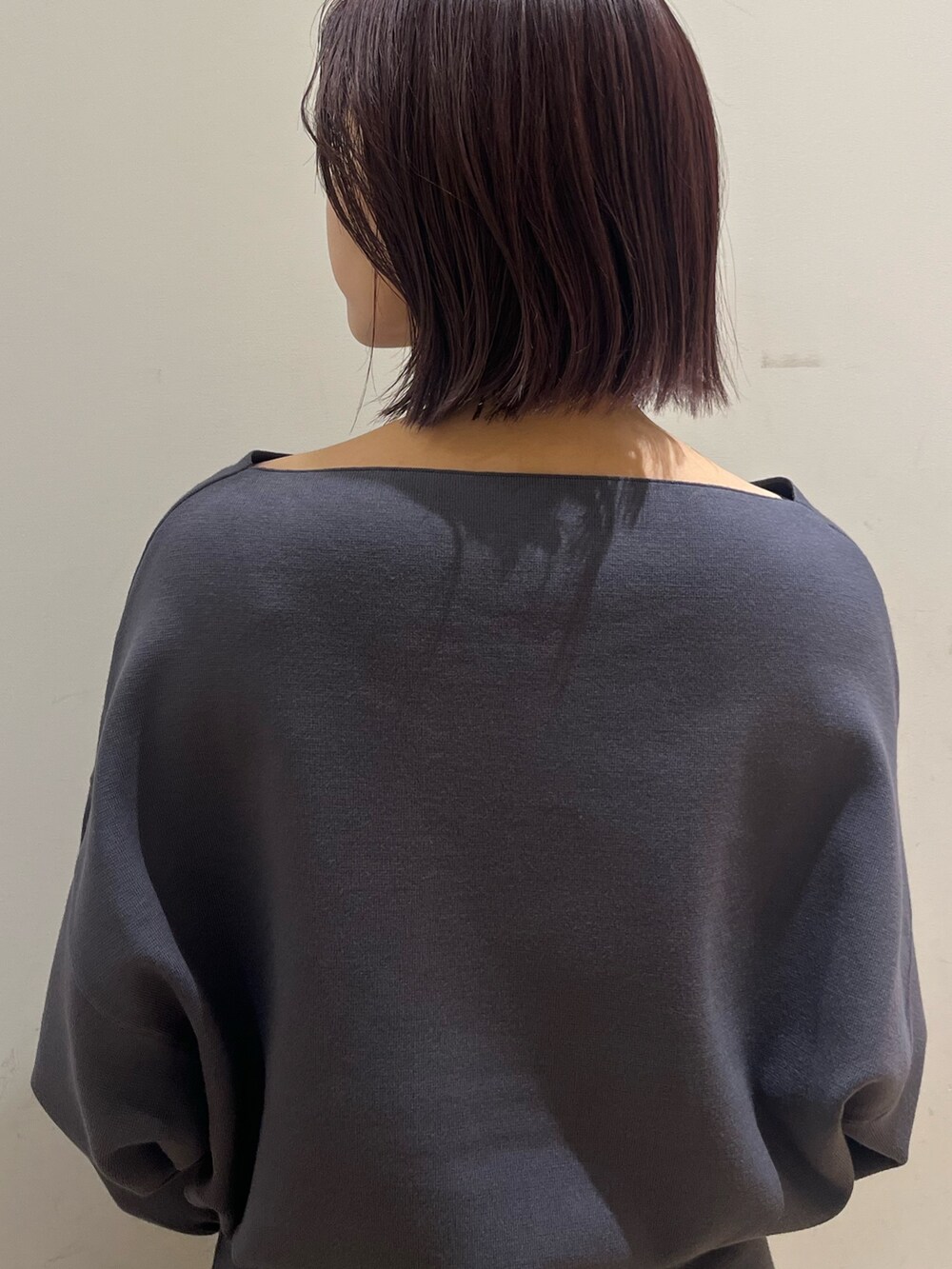 グレー系のスカート、グレー系のニット/セーター、シルバー系のブーツを着用したレディースの秋コーディネートの5枚目の写真