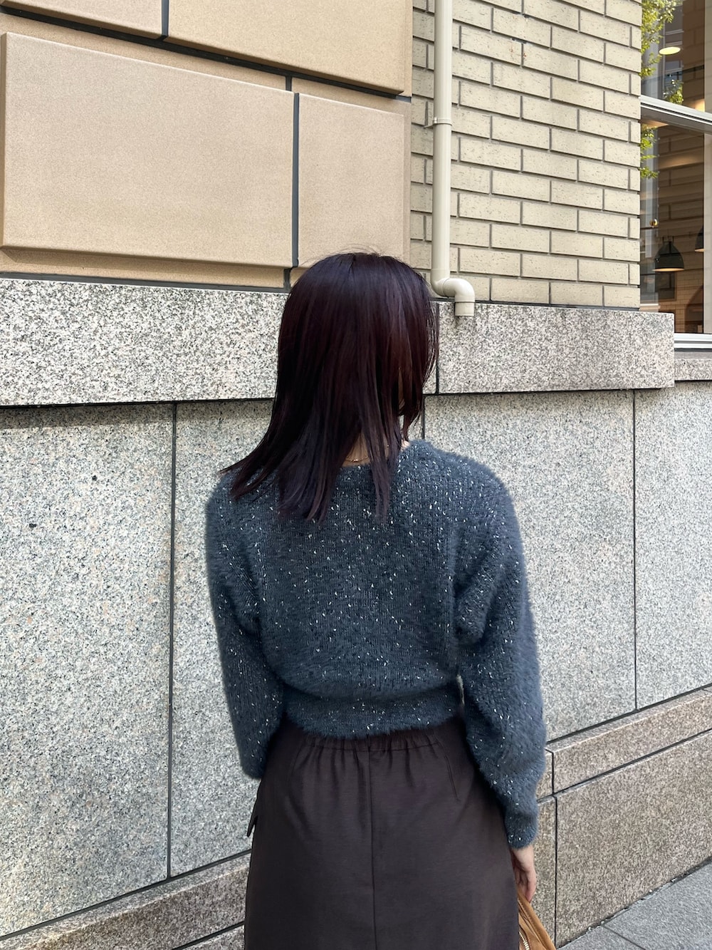 ブラウン系のハンドバッグ、グレー系のカーディガン/ボレロ、ブラウン系のスカートを着用したレディースの秋コーディネートの5枚目の写真