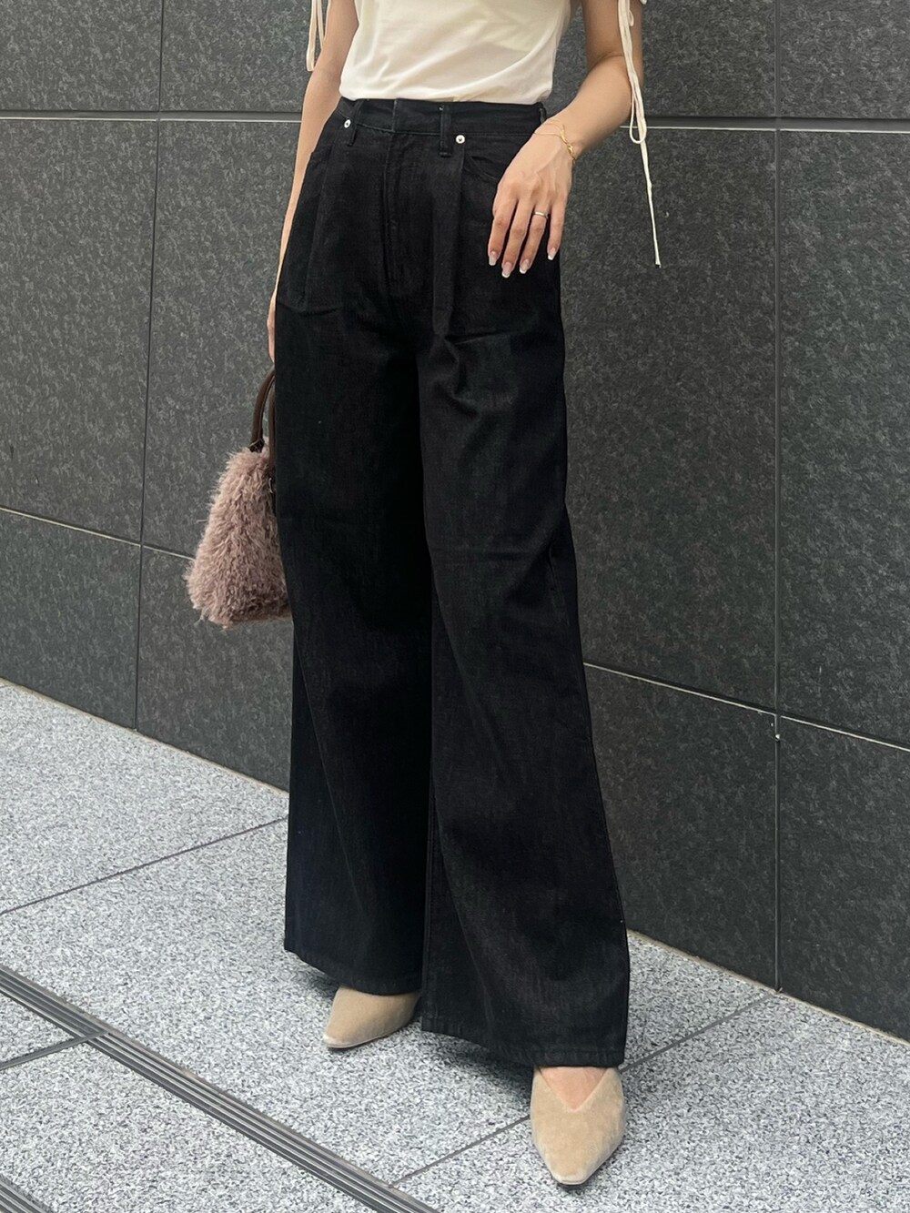 ホワイト系のTシャツ/カットソー、ブラック系のデニムパンツ、ベージュ系のパンプスを着用したレディースの夏コーディネートの4枚目の写真