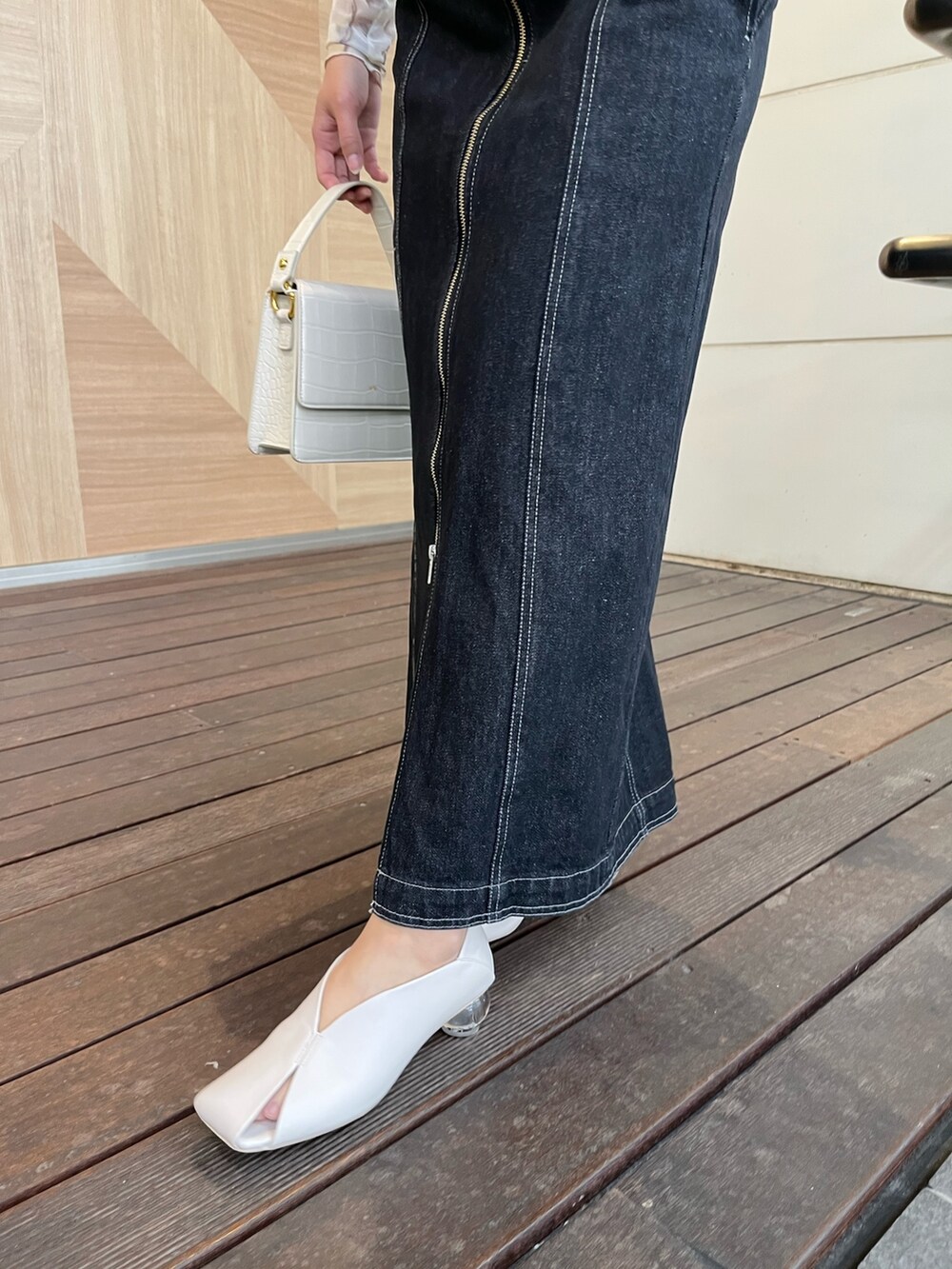 ホワイト系のパンプス、ホワイト系のショルダーバッグ、ブラック系のワンピースを着用したレディースの春コーディネートの6枚目の写真