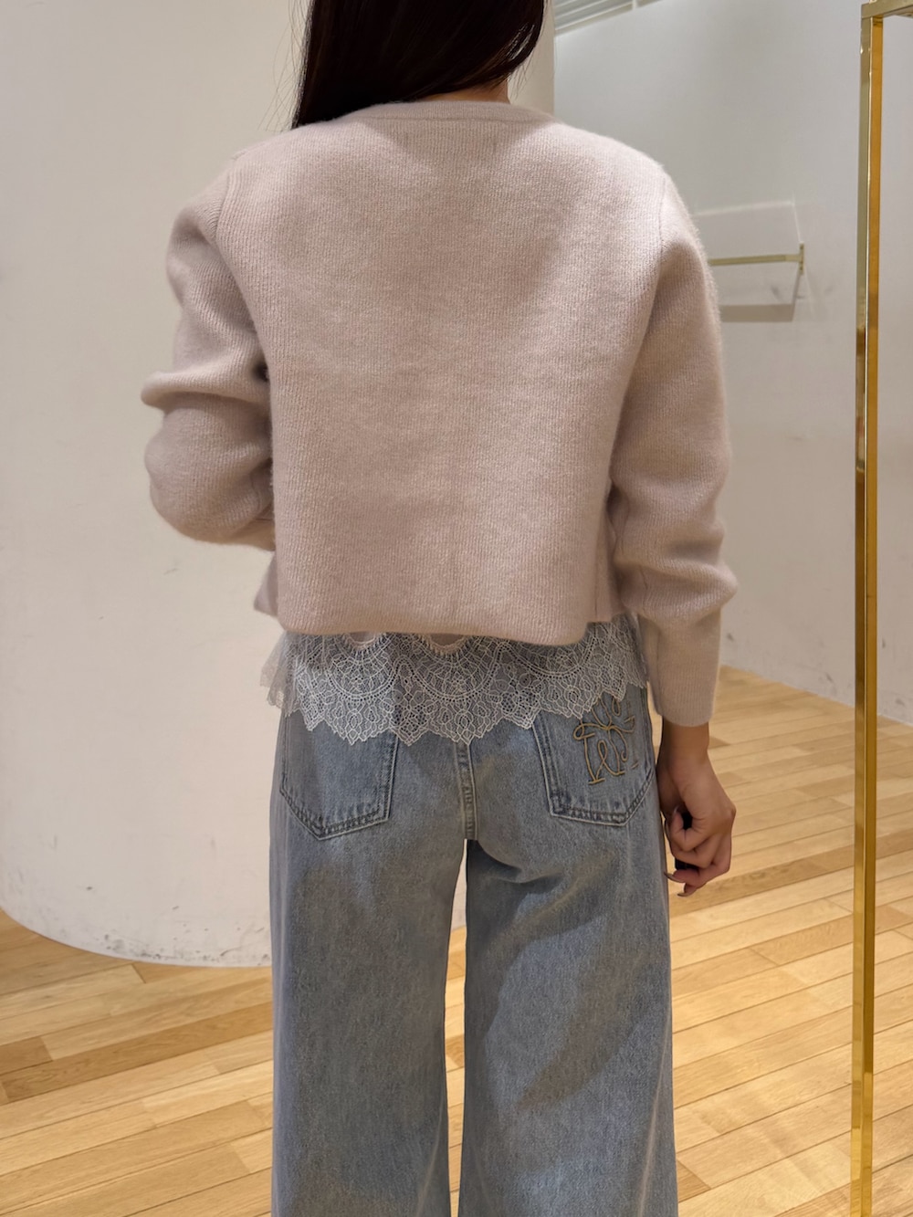 ベージュ系のノーカラージャケット、ベージュ系のキャミソール、ブルー系のデニムパンツを着用したレディースの秋コーディネートの5枚目の写真