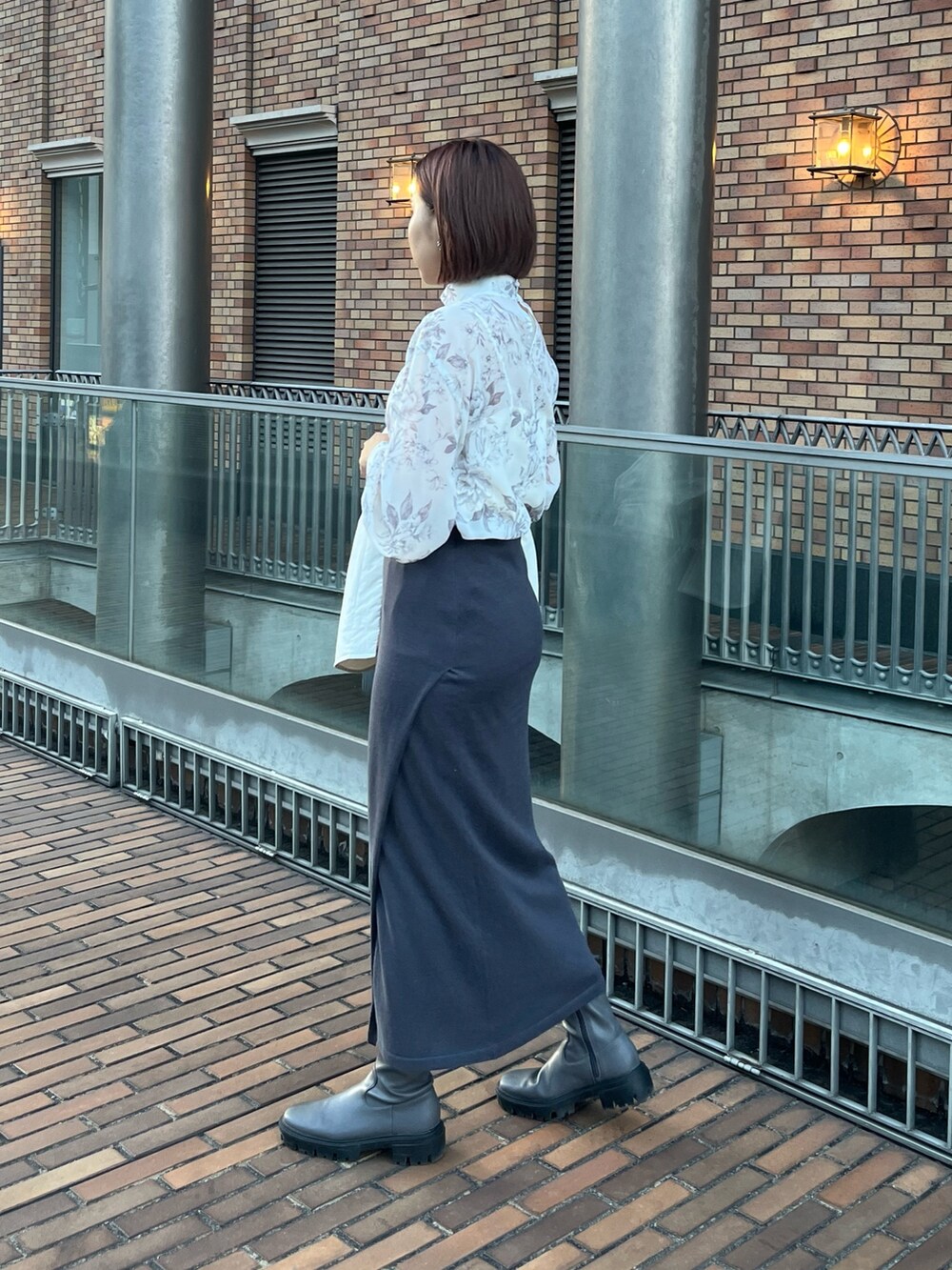 ブルー系のショルダーバッグ、グレー系のスカート、ホワイト系のブルゾンを着用したレディースの冬コーディネートの6枚目の写真