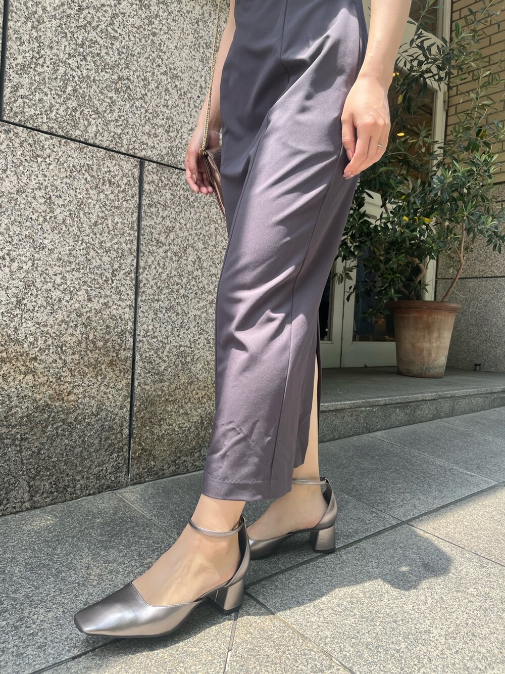 グレー系のドレス、ゴールド系のハンドバッグ、その他のパンプスを着用したレディースの夏コーディネートの6枚目の写真