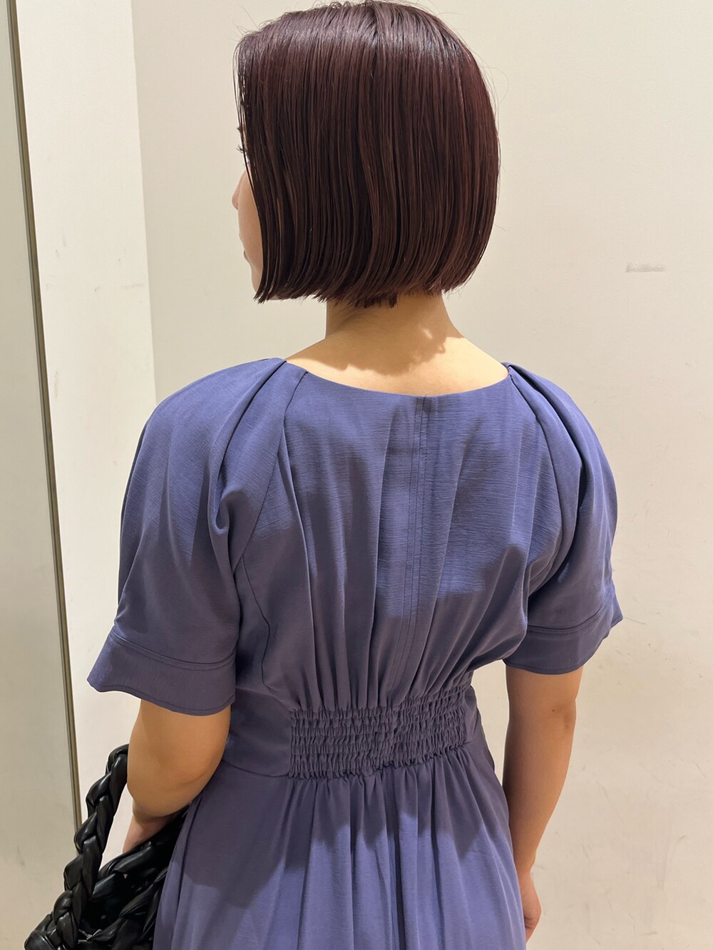 ブルー系のワンピース、ブラック系のハンドバッグ、ホワイト系のスニーカーを着用したレディースの夏コーディネートの5枚目の写真