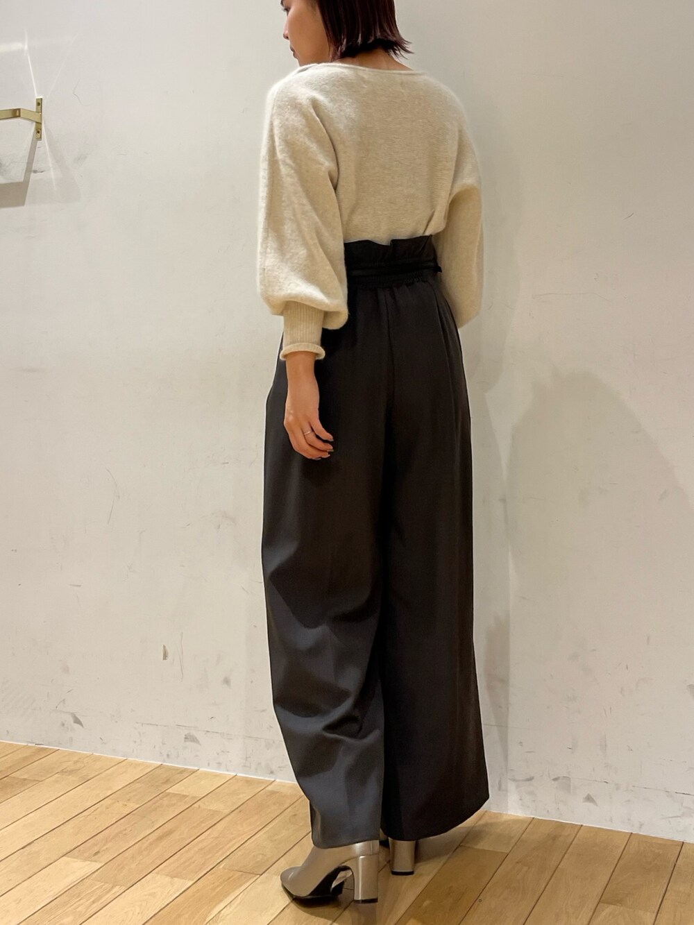 グレー系のその他パンツ、ホワイト系のニット/セーター、シルバー系のブーツを着用したレディースの秋コーディネートの3枚目の写真