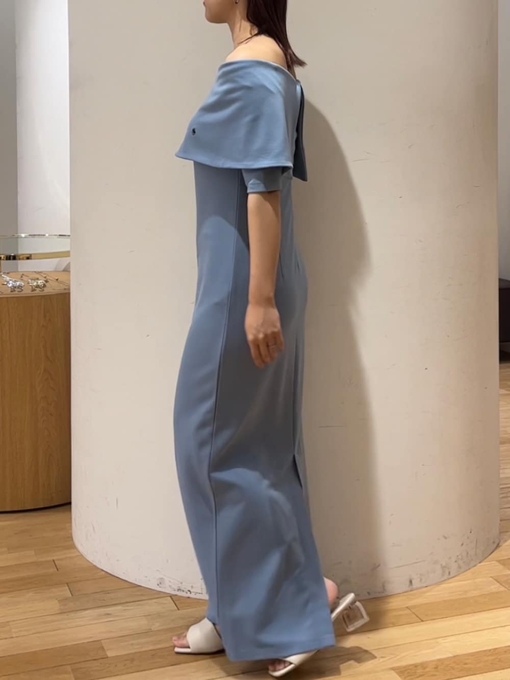 ブルー系のワンピース、ホワイト系のサンダル、グレー系のキャップを着用したレディースの春コーディネートの2枚目の写真