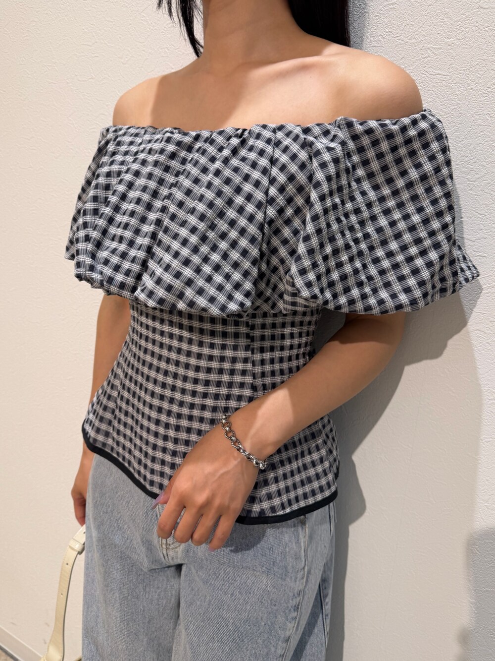 ブルー系のデニムパンツ、ホワイト系のサンダル、ホワイト系のハンドバッグを着用したレディースの夏コーディネートの7枚目の写真