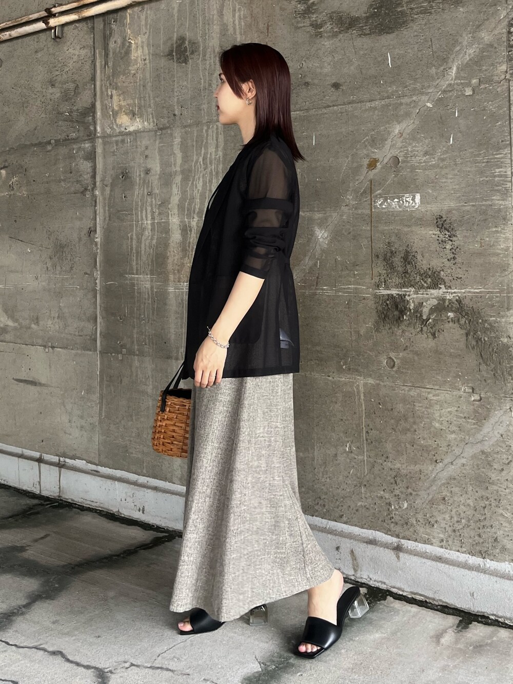 ブラック系のテーラードジャケット、ブラウン系のワンピース、ブラウン系のハンドバッグを着用したレディースの夏コーディネートの2枚目の写真