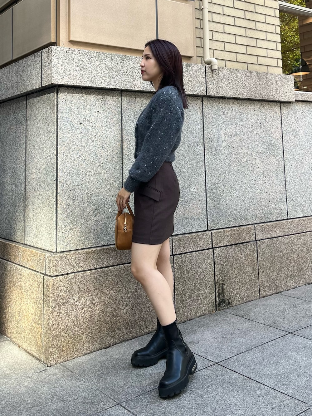 ブラウン系のハンドバッグ、グレー系のカーディガン/ボレロ、ブラウン系のスカートを着用したレディースの秋コーディネートの2枚目の写真