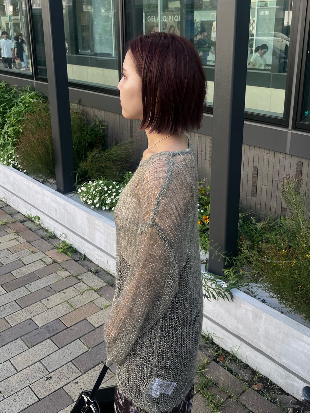 ブラック系のショルダーバッグ、グレー系のニット/セーター、ブラウン系のスカートを着用したレディースの秋コーディネートの5枚目の写真