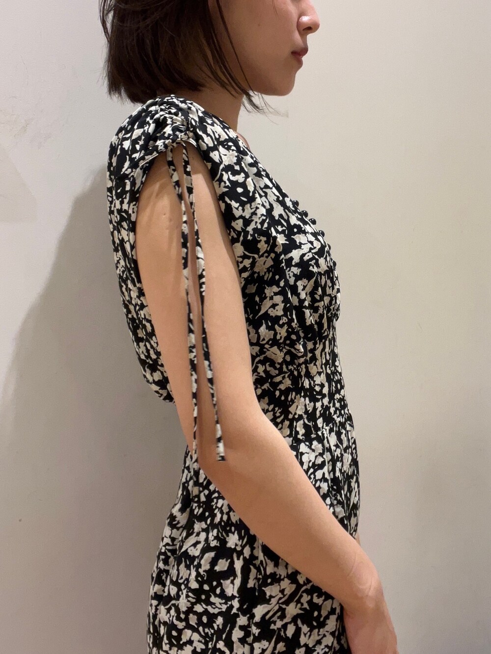 ブラック系のワンピース、ブラック系のハンドバッグ、ブラック系のサンダルを着用したレディースの春コーディネートの3枚目の写真