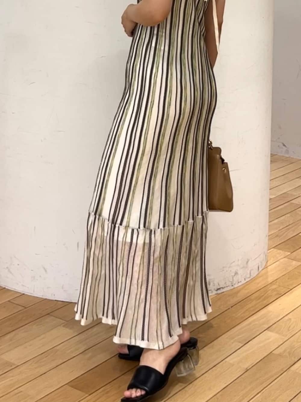 ブラウン系のハンドバッグ、ホワイト系のワンピース、ベージュ系のテーラードジャケットを着用したレディースの春コーディネートの6枚目の写真