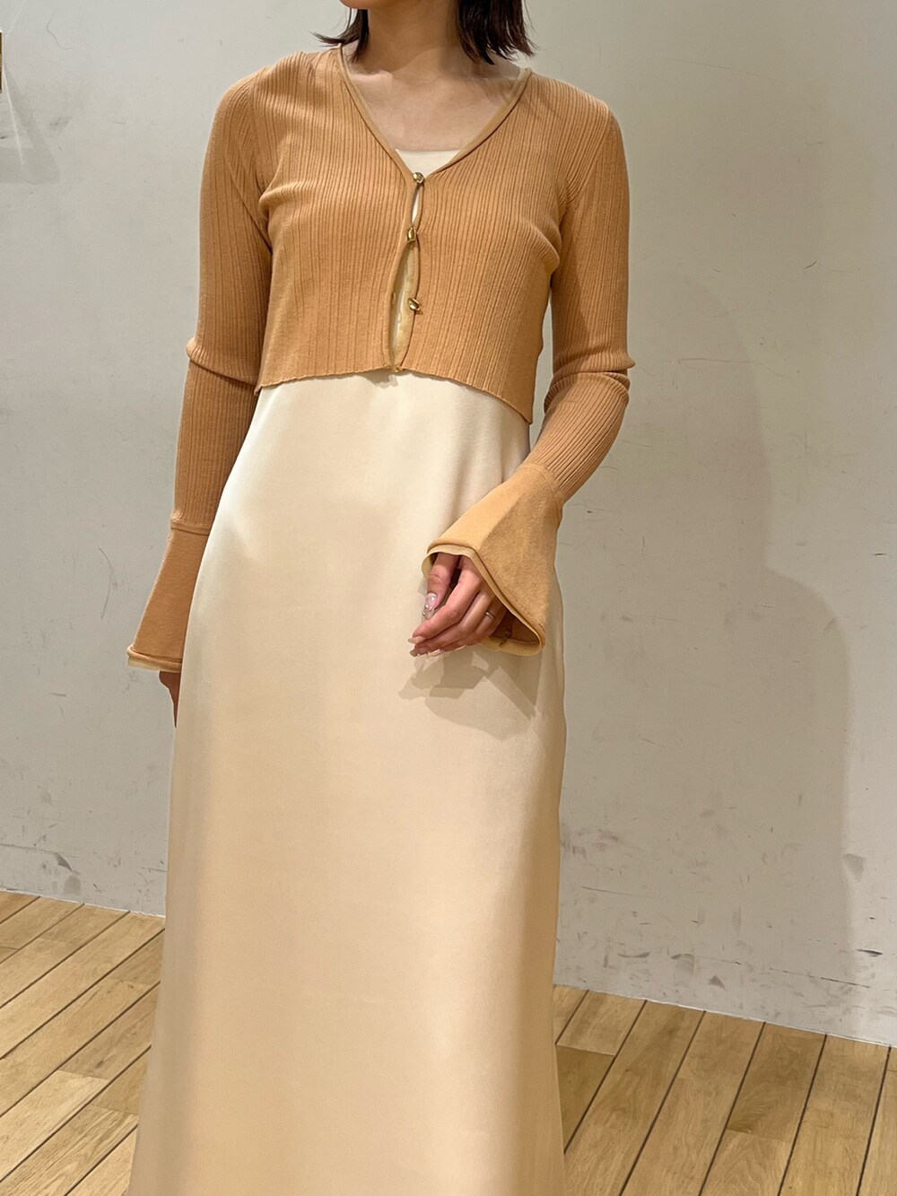 オレンジ系のワンピース、グレー系のスニーカーを着用したレディースの冬コーディネートの4枚目の写真