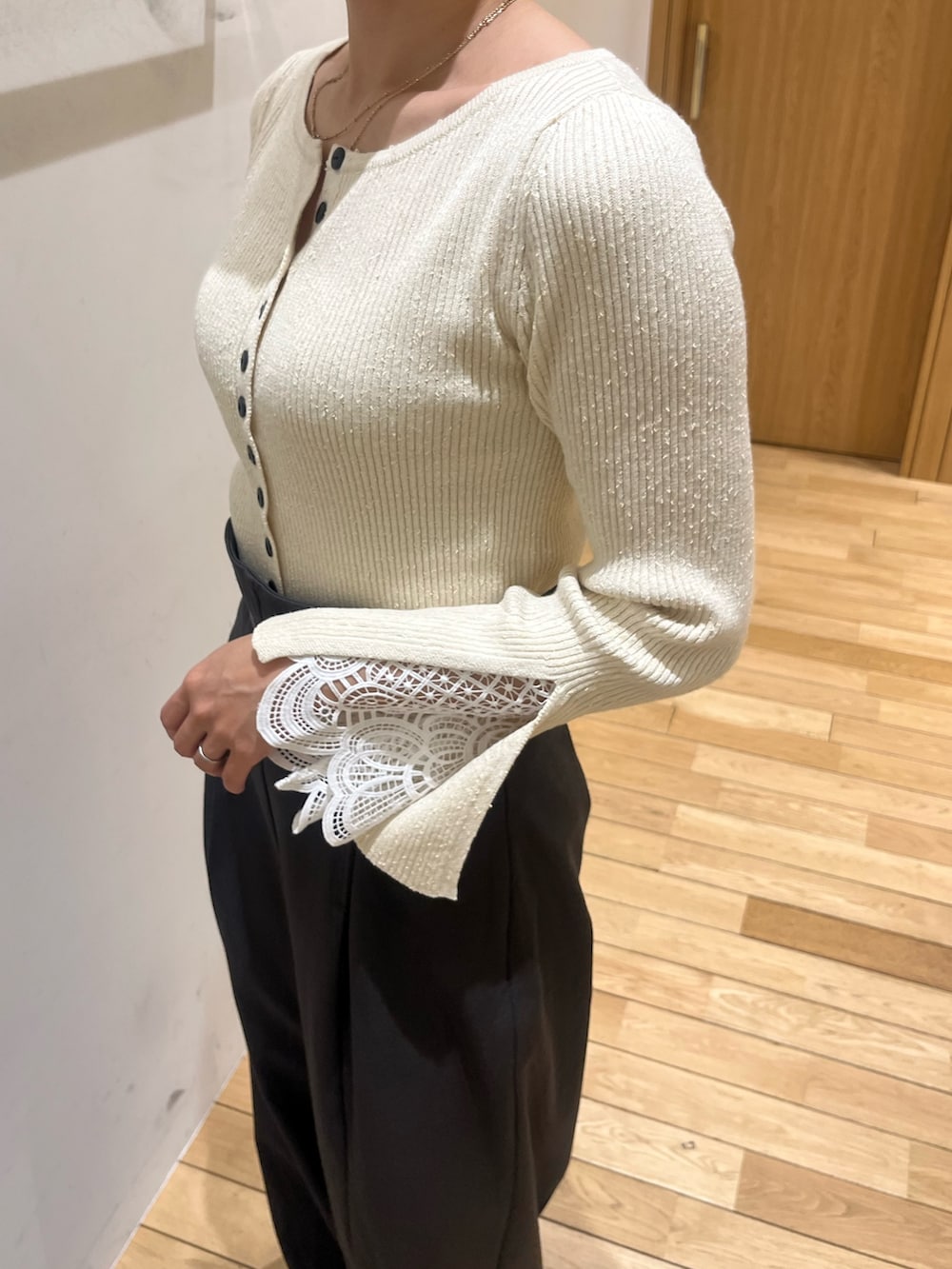 グレー系のその他パンツ、ホワイト系のニット/セーター、ブラウン系のハンドバッグを着用したレディースの冬コーディネートの5枚目の写真