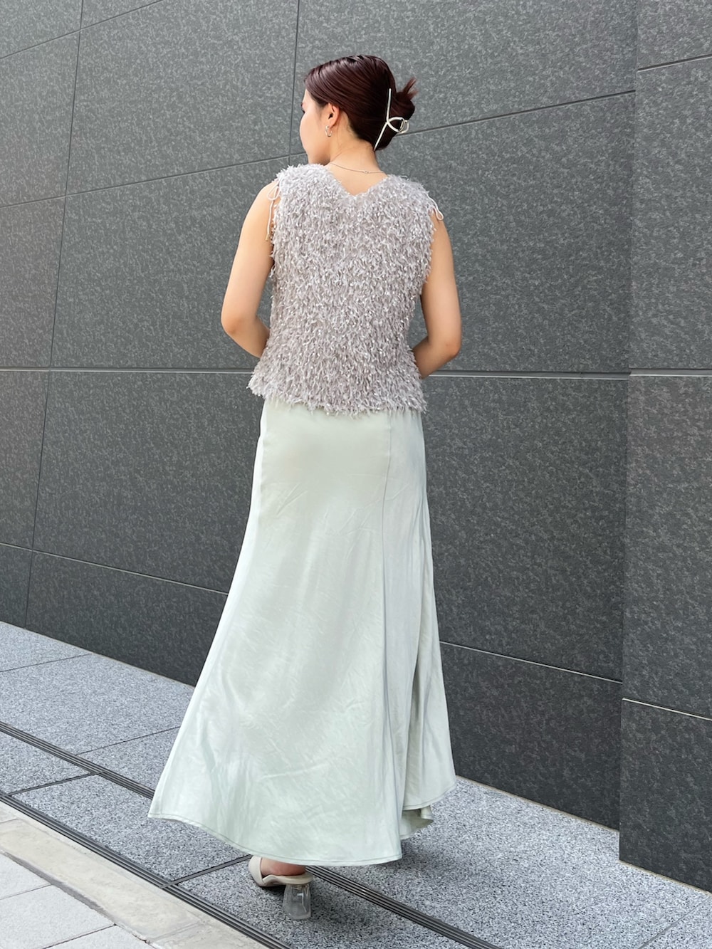 グレー系のTシャツ/カットソー、グリーン系のスカート、ホワイト系のサンダルを着用したレディースの夏コーディネートの3枚目の写真