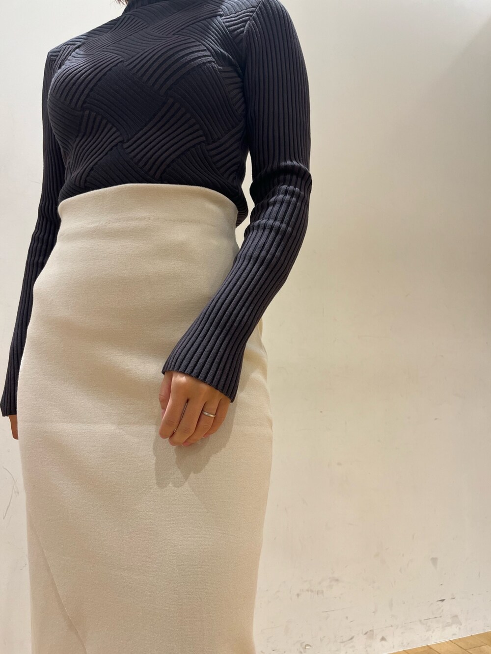 グレー系のニット/セーター、ブラック系のショルダーバッグ、ブラック系のブーツを着用したレディースの冬コーディネートの5枚目の写真