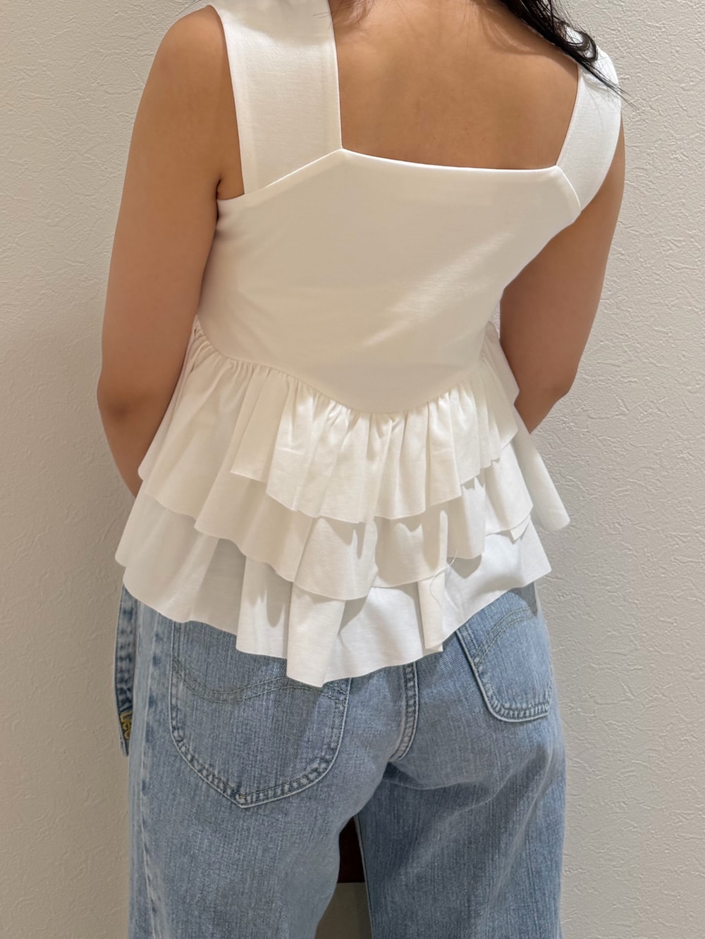 ブルー系のデニムパンツ、ホワイト系のタンクトップ、ブラウン系のハンドバッグを着用したレディースの夏コーディネートの6枚目の写真