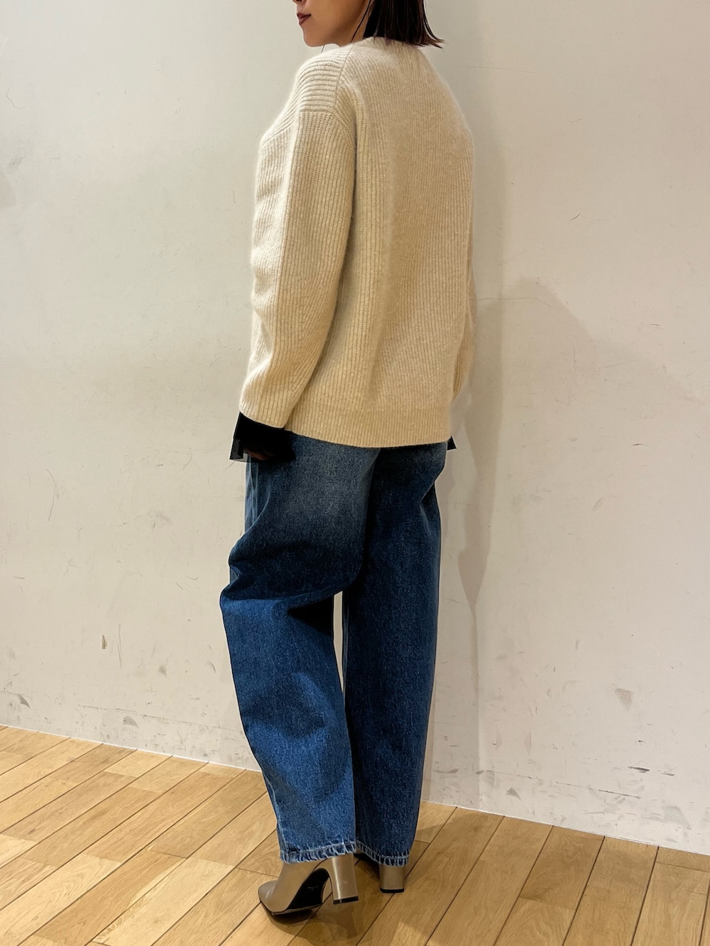 シルバー系のブーツ、ブルー系のデニムパンツ、ブラック系のTシャツ/カットソーを着用したレディースの秋コーディネートの3枚目の写真