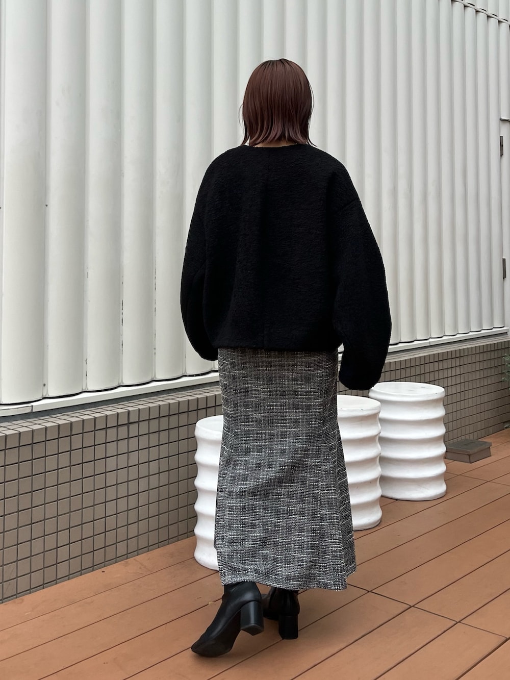 ブラック系のブルゾン、ブラック系のニット/セーター、ブラック系のスカートを着用したレディースの秋コーディネートの3枚目の写真